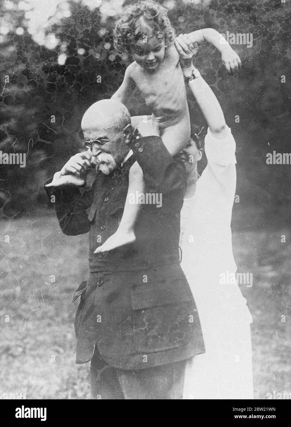 Le Dr T. J. Masaryk, fondateur et premier président de la République tchécoslovaque, gravement malade après un accident vasculaire cérébral au château de Lany, à 20 km de Prague. Le Dr Masaryk, 87 ans, joue avec l'un de ses petits-enfants. 2 septembre 1937 Banque D'Images