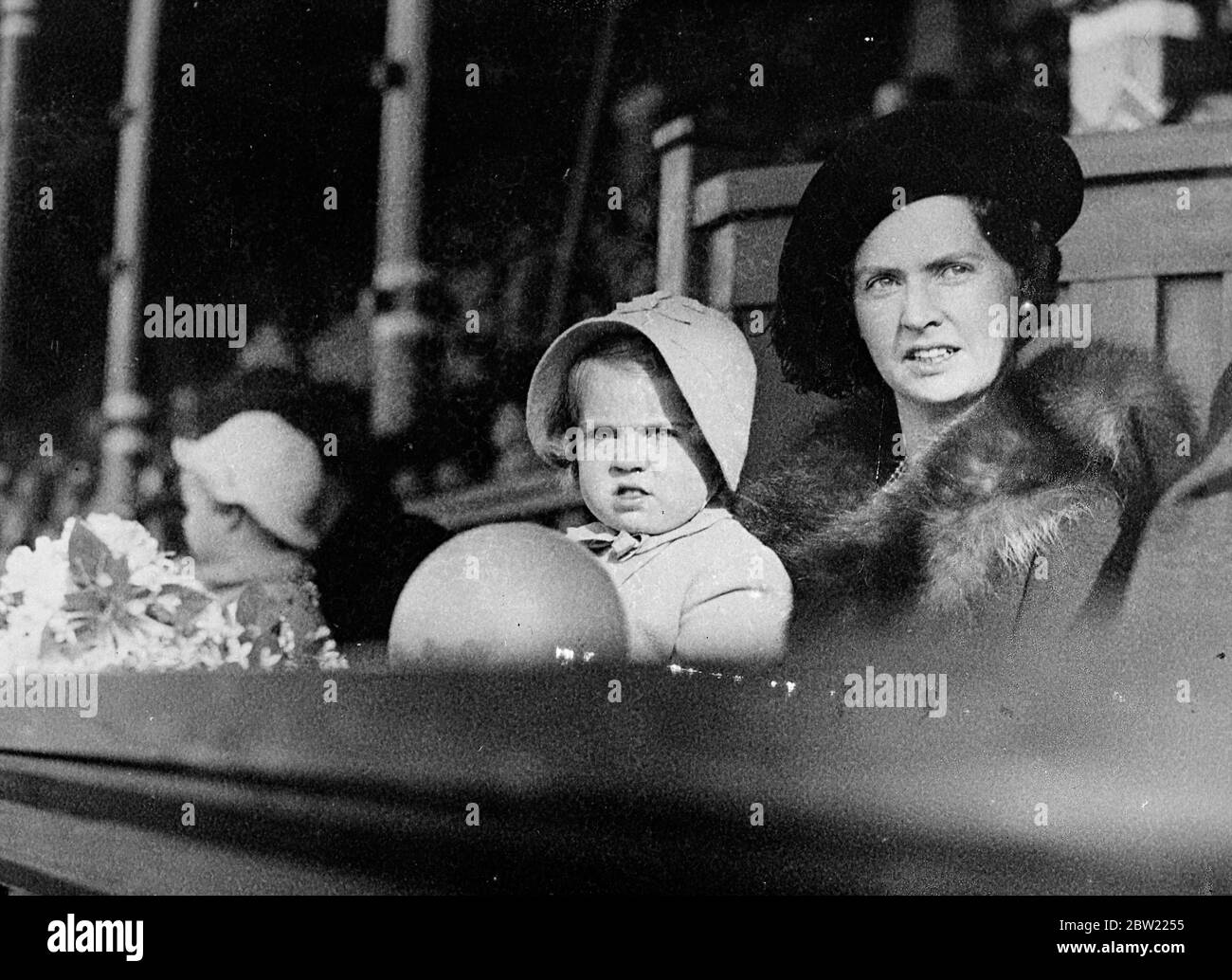 La petite princesse Margaretha de Suède oublie son ballon de jouet comme elle suit avec l'attention de raft une parade des rois de Suède au stade de Stockholm, où la Journée des enfants a été célébrée. Avec la petite princesse est sa mère la princesse Sibylla, épouse du prince Gustaf Adolf, fils du prince héritier. 22 septembre 1937 Banque D'Images