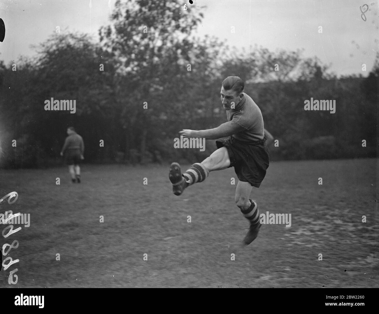 Ben Fenton fait un coup de pied énergique de la chambre à Upton Park pour son match de première ligue. Ben Fenton, 18 ans, Reserve, dirigera l'attaque de West Ham contre Felling samedi les réalisateurs de West Ham ont été tellement impressionnés par son exposition dans la coupe de défi lundi, lorsqu'il a marqué trois buts contre Clapton Orient à la décision de lui donner la chance. Ce sera sa première apparition dans l'équipe de ligue. 6 octobre 1937. Banque D'Images