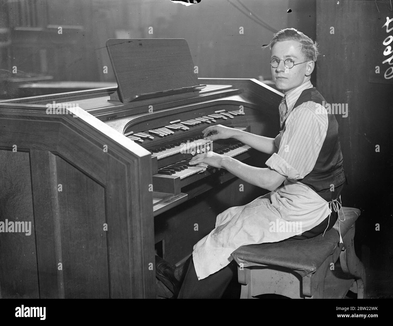 Frederick Pratt, 16 ans, a sauvé le service du festival de la récolte qui se tiendra lundi à l'église St Marks, à Dalston. Bien qu'il ait eu seulement six leçons d'orgue dans sa vie, Frederick, qui est employé par la société de constructeurs d'orgue du nord de Londres, jouera l'orgue à son service et dirigera le choeur de 18 garçons et 10 hommes qu'il a lui-même répété. Sa chance est venue quand l'organiste de l'église est tombé malade et il a demandé au vicaire, le révérend J. O. Vince, s'il pouvait jouer pour le service. 23 septembre 1937 Banque D'Images