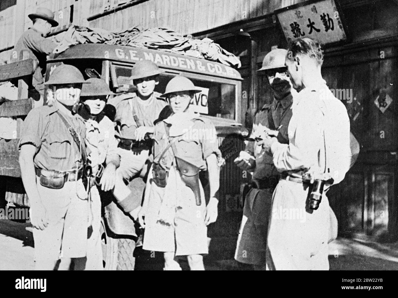Les membres américains du corps de volontaires de Shanghai évacuaient des civils chinois de la zone de bataille du district de Yangtsepoo [district de Yangpu]. Un bébé est né dans son camion comme il était en route vers le règlement international. Un photographe américain R. R. Brandt se trouve à droite. 21 septembre 1937 Banque D'Images