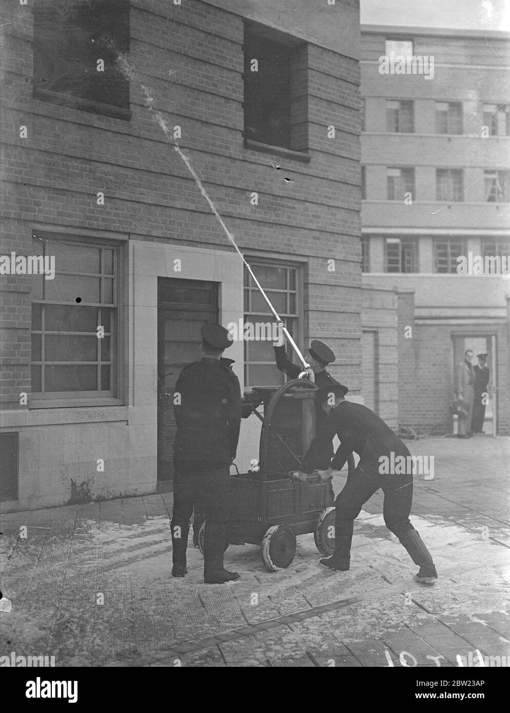 Les anciennes et nouvelles méthodes de lutte contre les incendies ont été démontrées par la brigade des pompiers de Londres lors d'une exposition devant le chef des pompiers de toutes les régions d'Angleterre au quartier général de la brigade à Londres. Des appareils d'incendie des siècles passés et l'équipement le plus à jour ont été utilisés pour l'affichage. Pompiers qui travaillent une ancienne pompe manuelle du XVIIIe siècle pour étouffer un feu. 13 octobre 1937 Banque D'Images