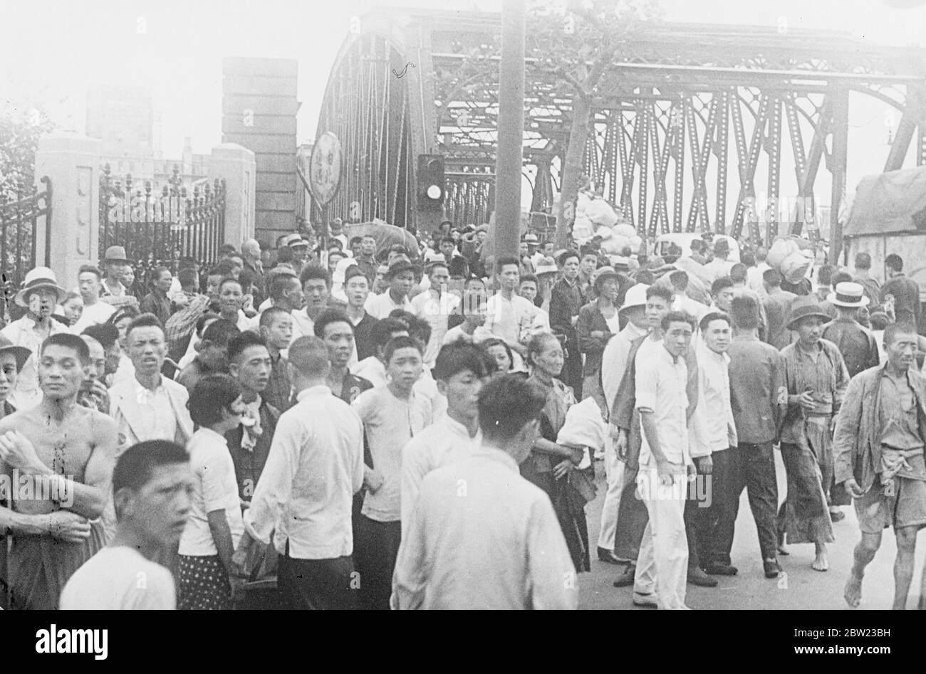 Cette photo, qui vient d'être reçue de Shanghai à Londres, montre une scène effrayante dans le Grand monde, le centre d'amusement de Shanghai, dans lequel 800 personnes ont été tuées lors d'un raid aérien. Le carnage et la ruine terribles ont été introduits dans la ville par le bombardement aérien et d'artillerie continu alors que les Japonais se sont lentement fermés. Des corps mutilés étaient éparpillés partout dans le parc. Les réfugiés traversent le pont du jardin pour rejoindre le règlement international de Shanghai. 2 septembre 1937 Banque D'Images