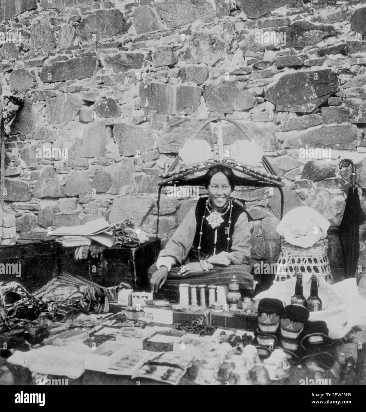 Dans le pays peu connu des Lamas. Ces photos ont été faites par des membres d'une expédition envoyée dans la 'Terre interdite' des Lamas, le Tibet, le mystérieux pays qui borde l'Inde et la Chine. Ce n'est qu'après cinq ans de négociations que l'expédition a été autorisée à visiter Lhassa, la ville sainte, où seulement une douzaine d'hommes blancs sont connus pour être entrés. Photos, est vu sur le marché de Shigatse deuxième plus grande ville du Tibet. La femme porte la coiffure Shigatse typique et autour de son cou une boîte d'or et turquoise qui contient des prières. Banque D'Images