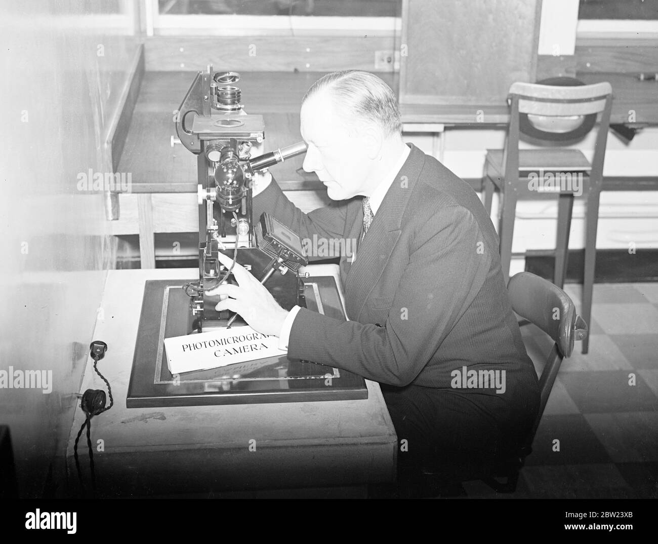 M. Walter Elliott, ministre de la Santé, a ouvert les nouveaux laboratoires de recherche de la Metropolitan Water Board au siège de la Commission, à Rosebery Avenue, Clerkenwell, Londres. Photos: M. Walter Elliot, exploitant une caméra photomicrographique dans les laboratoires. L'appareil photo est utilisé pour photographier des échantillons d'eau. 17 octobre 1938 Banque D'Images