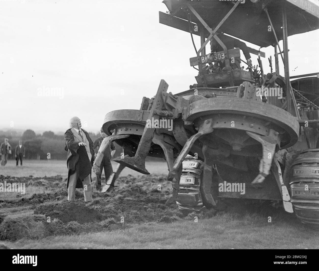 Utilisant un nouveau gyrotimon, une charrue pour creuser, et des hommes travaillant jour et nuit. M. Lloyd George, politicien vétéran qui a maintenant 75 ans, transforme en un temps record 160 acres de terres inutilisées en un jardin de marché. La terre, qui rejoint sa ferme à Churt, Surrey, n'a pas été intensément cultivée depuis de nombreuses années, mais déjà la moitié de la superficie est prête pour la plantation. Les hommes travaillent la nuit par projecteur. Photos: Monsieur Lloyd George regardant le gyrotimon rotatif au travail sur sa nouvelle ferme. 17 octobre 1938 Banque D'Images