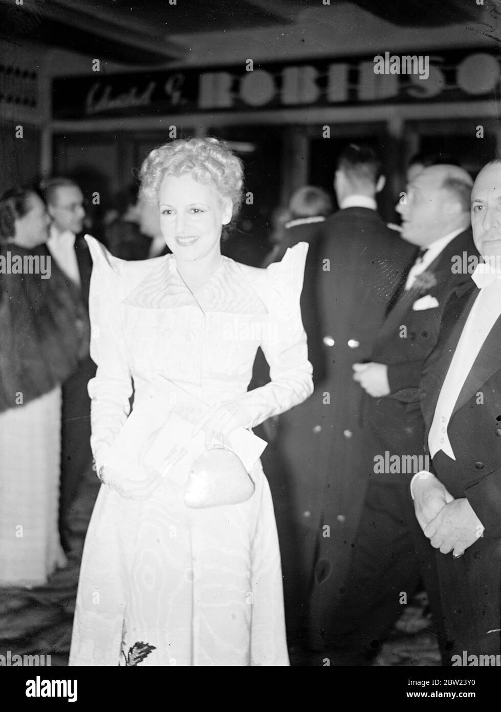 Une mode inhabituelle portée par l'attrayante Mme Max Milder lorsqu'elle est arrivée pour l'ouverture du Warner Theatre à Leicester Square, Londres, où la première des aventures de Robin des Bois a été donnée en aide à la campagne contre le cancer de l'Empire britannique. Le duc et la duchesse de Kent y ont assisté le 12 octobre 1938 Banque D'Images