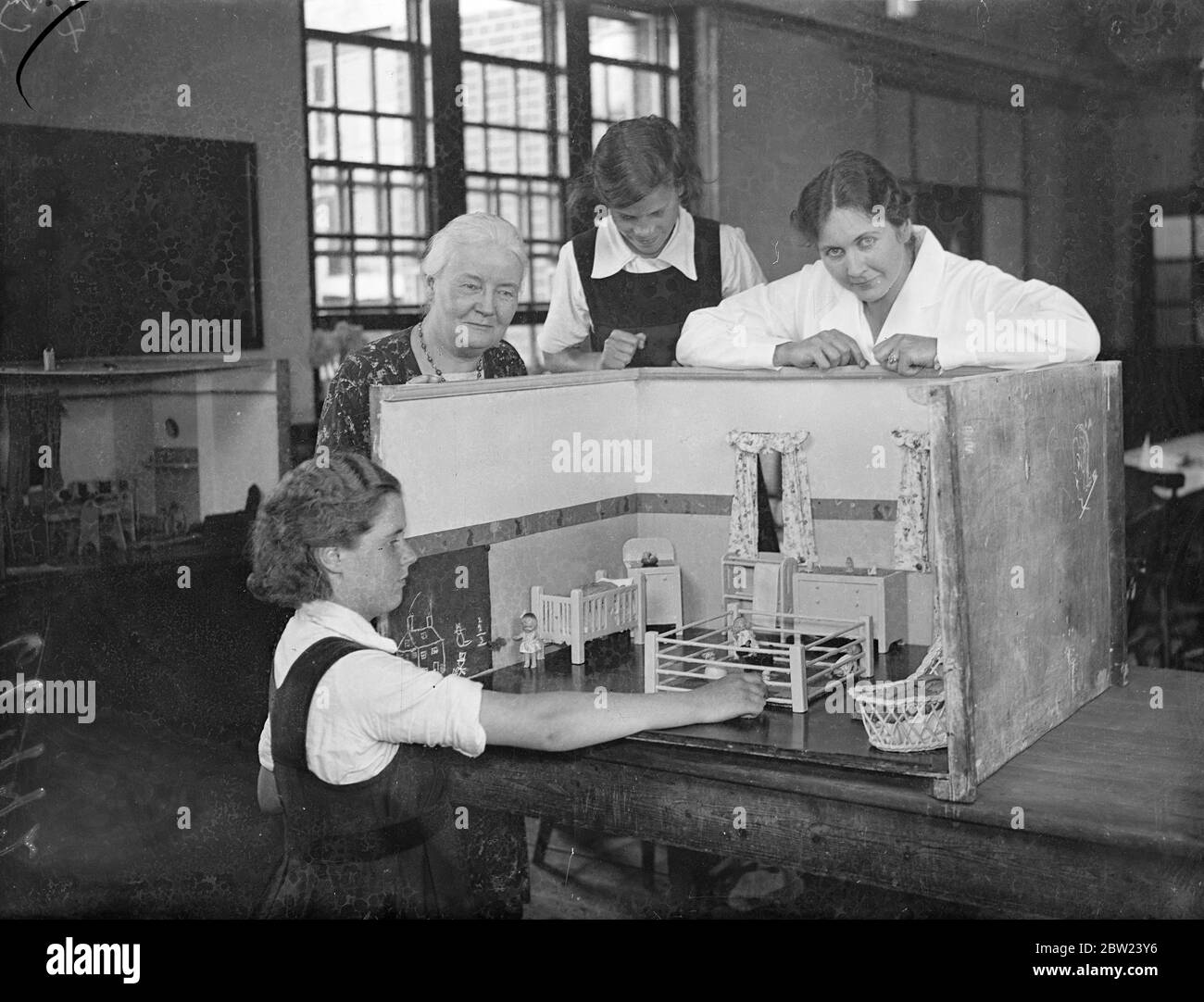 Mlle er Broom , ( gauche ) maîtresse, avec deux élèves qui ont fait un modèle de pépinière avec des meubles. Le modèle doit être montré aux filles de l'école du comté d'Enfield pour montrer les avantages de divers schémas dans la décoration et l'ameublement. 24 juillet 1937. Banque D'Images