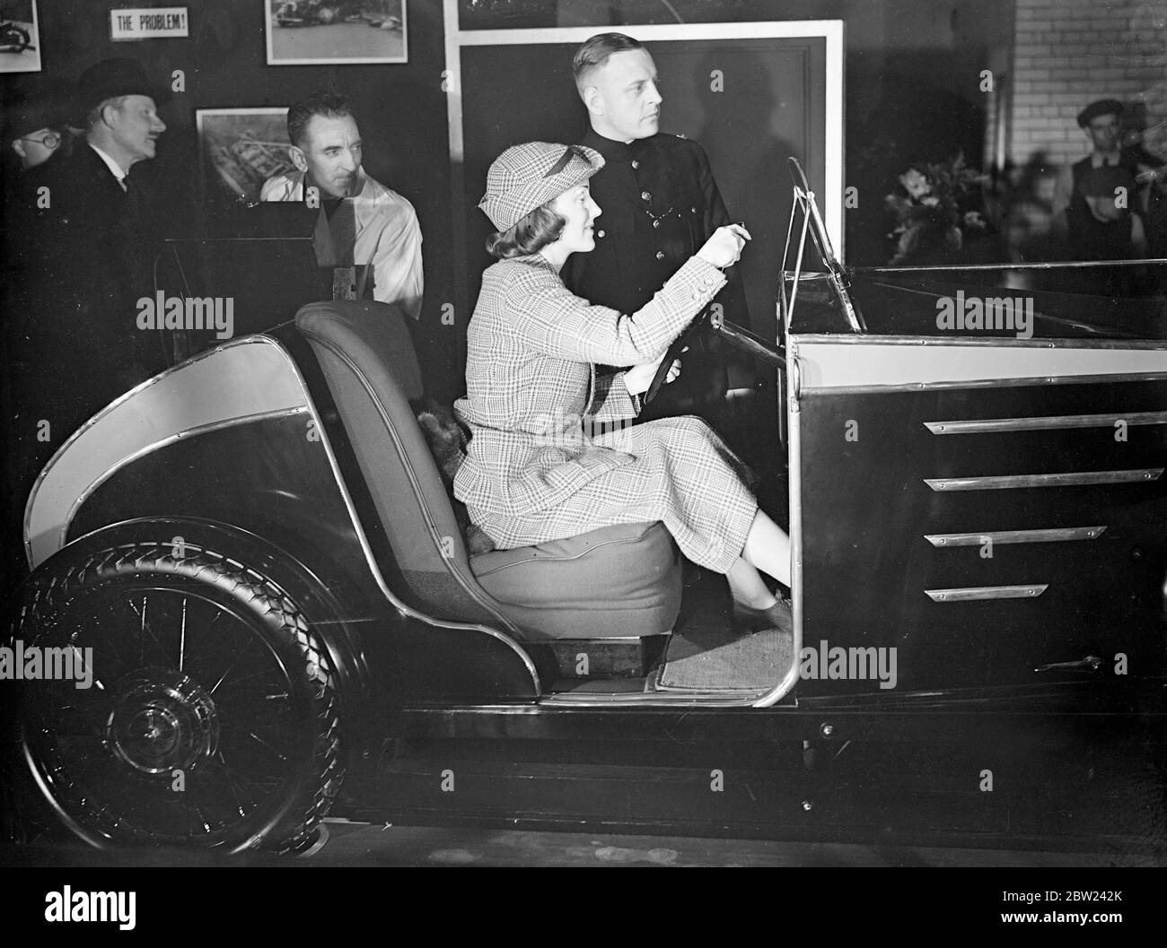 Judy Shirley, la chanteuse radio, au volant de la voiture d'essai sur le stand de police au Motor Show qui a ouvert à Earls court, Olympia, Londres. La commande de cette voiture par le conducteur est indiquée sur le tableau des indicateurs à l'avant du véhicule. 13 octobre 1938 Banque D'Images