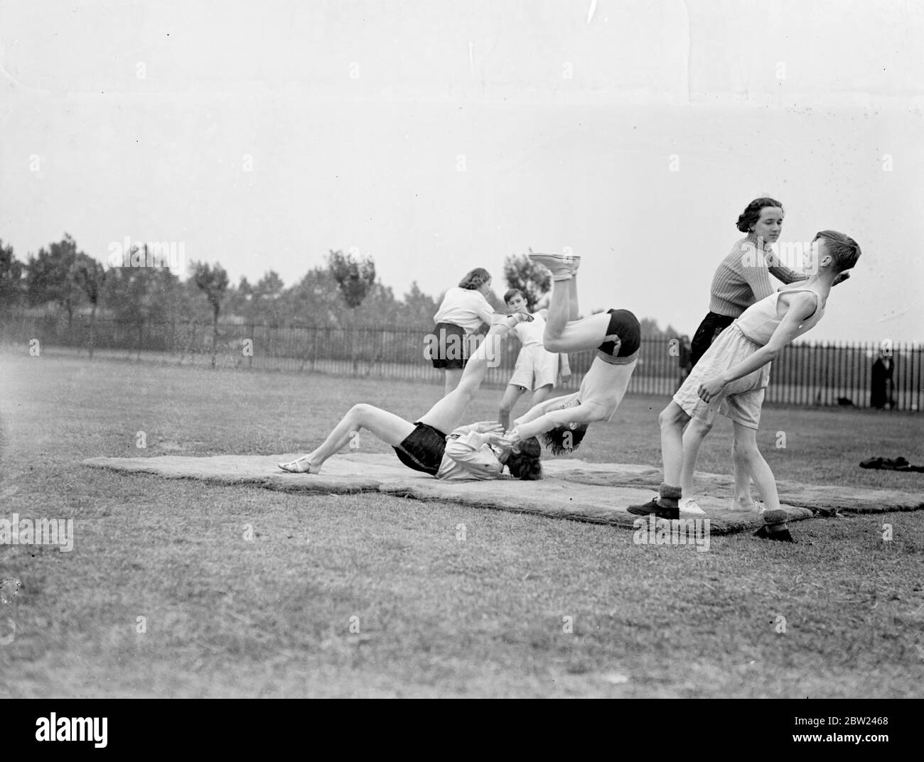 Un nouveau genre de guerre des sexes est inclus dans le programme de formation physique de l'école Barking Abbey School, Essex, où les filles et les garçons prennent des leçons dans la science du jujitsu et prennent souvent part à des épisodes mixtes. Photos montre: Un jet d'estomac et un brassard préféré par les filles à l'école. 5 octobre 1938 Banque D'Images