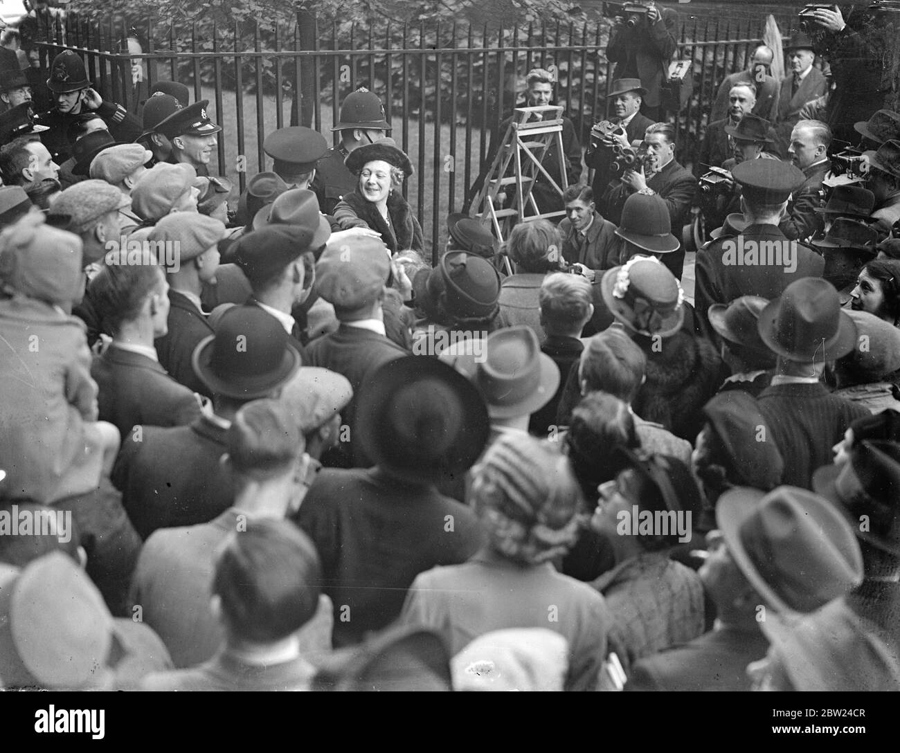 La foule applaudit Mme Chamberlain dans Downing Street. Mme Chamberlain, l'épouse du premier ministre, a été chaleureusement acclamé par la foule appréciant les efforts de nos maris pour préserver la paix mondiale lorsqu'elle a quitté le 10, Downing Street aujourd'hui (vendredi). Mme Chamberlain a parlé de quelques mots de reconnaissance. Des spectacles de photos, Mme Chamberlain s'est emparé des foules alors qu'elle quittait Downing Street. 30 septembre 1938 Banque D'Images