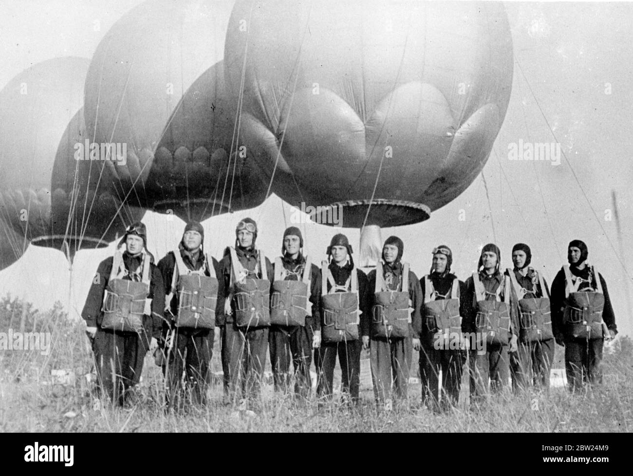 Ballon et parachutistes commencent nouvelle mode dans le travail de propagande. Un nouveau phénomène de propagande « hors du ciel » a été démontré par de jeunes parachutistes soviétiques lorsqu'ils ont pris le décollage dans six ballons et débarqué par parachute dans le district d'Istra (région de Moscou) Le parachutiste a ensuite effectué un travail de propagande parmi les agriculteurs collectifs en relation avec la Journée de l'aviation de l'Union et les célébrations du 20e anniversaire de la Ligue des jeunes communistes. Photos montre, les parachutistes prêts à monter dans les ballons. 22 août 1938 Banque D'Images