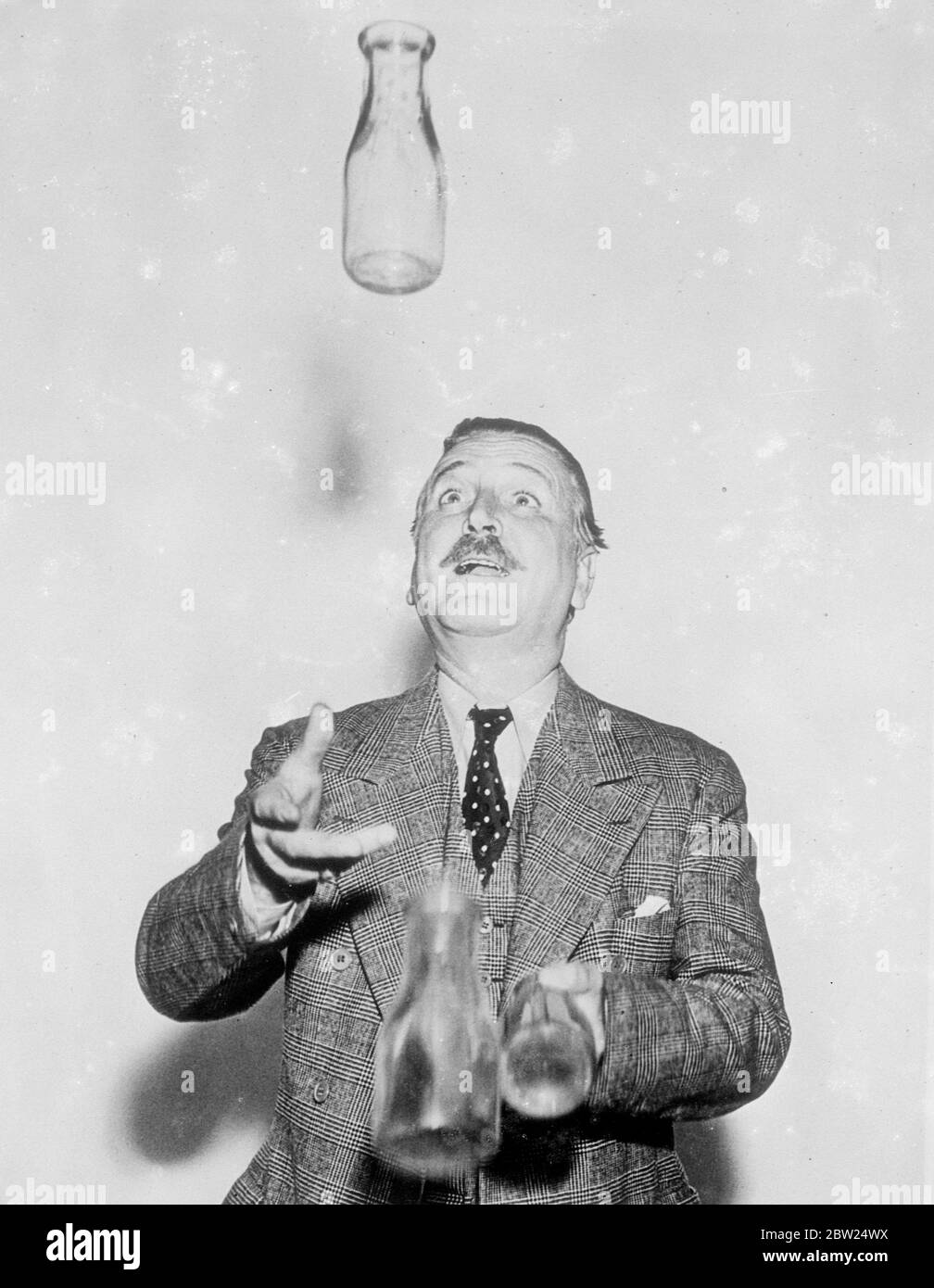 L'acteur du film tourne le conjuré et obtient une surprise. Avec trois bouteilles de lait vides et beaucoup d'espoir, Frank Morgan, l'un des meilleurs joueurs d'Hollywood, célèbre pour ses joviaux types, dépeint à l'écran, a pris l'occasion de divertir ses amis avec un jeu de jonglerie. Sa confiance était mal placée, cependant, car il a perdu le contrôle d'une bouteille et ne l'a trouvée que lorsqu'elle le frappe sur la tête. Des photos montrent que la confiance revient à Frank Morgan alors qu'il manipule les bouteilles avec détours, mais il est prévu pour une surprise. Banque D'Images