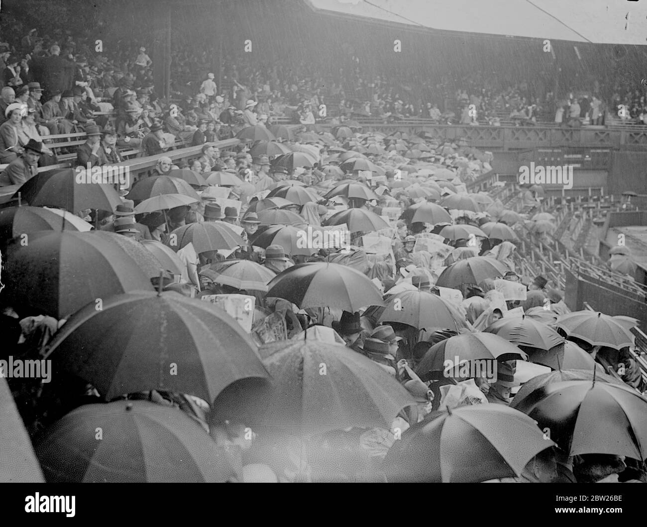 La pluie s'arrête au début de la demi-finale pour femmes de Wimbledon. Une déferle aiguë a cessé de jouer lorsque Mlle Helen Jacobs a rencontré sa paysprésidente, Mlle Alice Marble, dans les demi-finales des singles féminins des championnats de tennis de pelouse à Wimbledon, Londres. Photos, la mer de parasols sur le court central quand la pluie a arrêté de jouer au début du match. 30 juin 1938 Banque D'Images
