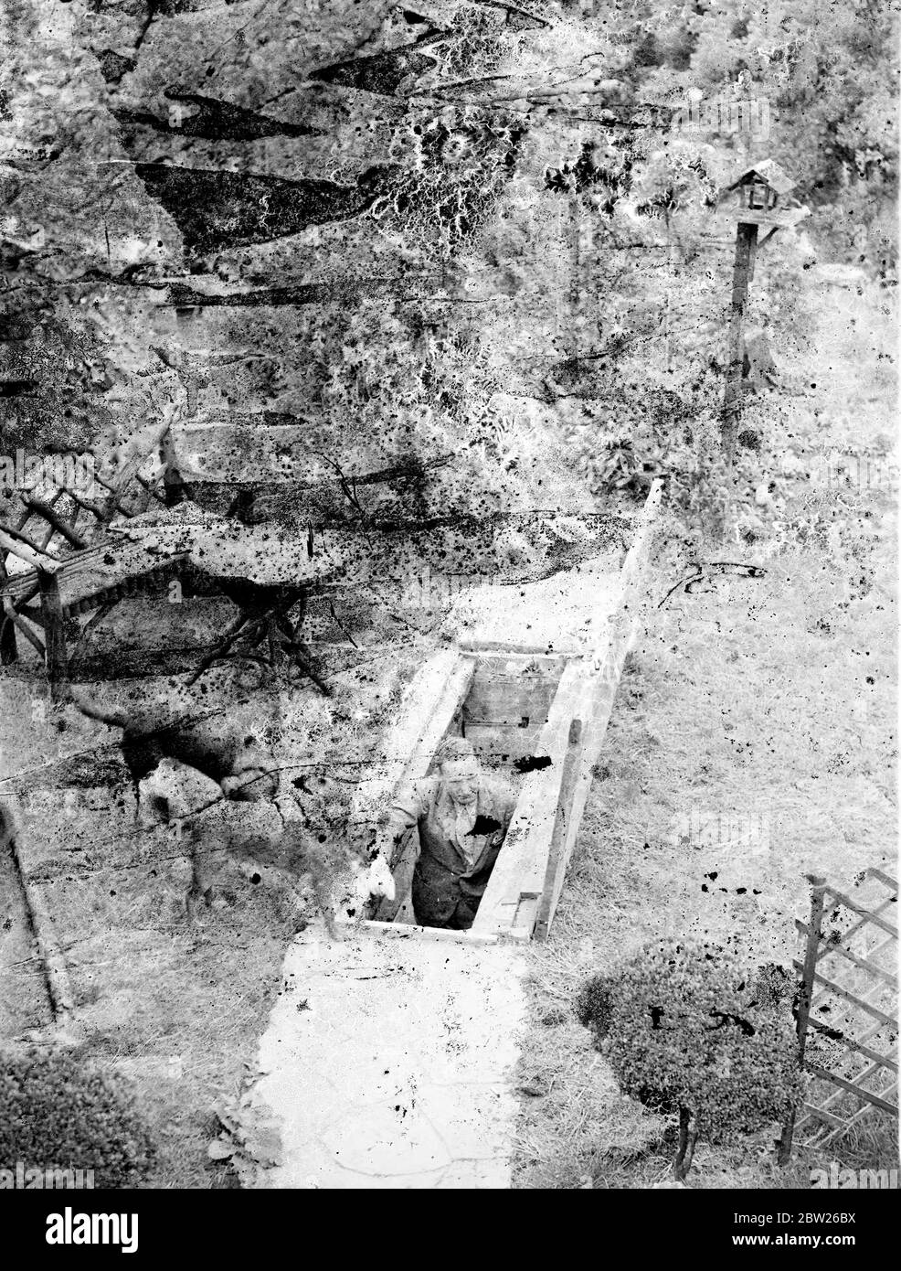 Perdu de vue et de mains dans la guerre, le Londoner a maintenant conçu un nouveau type de RAID anti-aérien. Un type peu coûteux d'abri de RAID aérien qui, selon lui, est largement supérieur à l'idée de « chambre à gaz » recommandée aux citoyens par le gouvernement a été conçu et installé dans le jardin de sa maison à Hampstead Garden, banlieue de Londres, par M. Alan N Nichols, Qui a perdu la vue et les deux mains pendant la Grande Guerre, il est le seul homme en Grande-Bretagne à souffrir de cette double incapacité. M. Nichols, a réalisé que dans la plupart des maisons de banlieue il est difficile de réserver une chambre comme abri d'air, il a donc conçu un Banque D'Images
