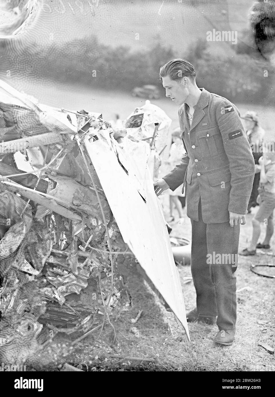 Le pilote et l'observateur s'évadent en parachute depuis l'avion de la RAF près de Speen. L'équipage de deux personnes s'est échappé par parachute lorsque le bombardier RAF s'est écrasé dans une colline près de Speen, Buckinghamshire, après avoir manqué d'essence. L'accident s'est produit à seulement 800 mètres de l'auberge Plough, une maison publique tenue par Mme Ridgloy, l'ancienne Miss Ishbel Macdonald. Le pilote et l'observateur ont atterri à 2 miles de distance, mais ils ont tous deux marché jusqu'à la même maison pour obtenir de l'aide. Photos, le chef de l'aviateur L A C Miller, l'observateur, regardant l'avion nausérage dont il s'est échappé par parachute. 2 août 1938 Banque D'Images
