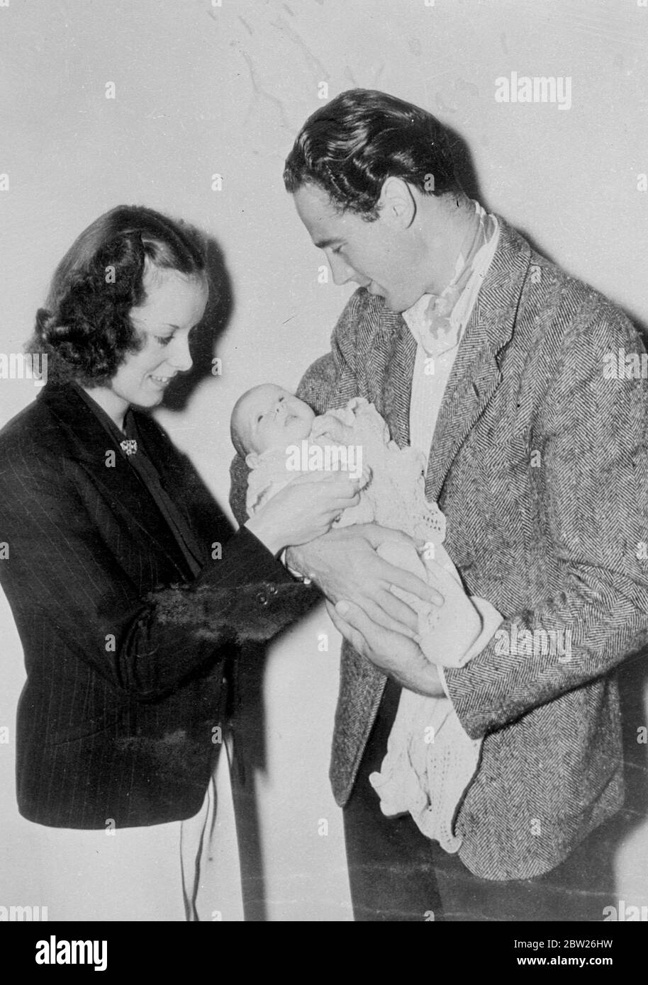 Patrick Knowles admire son fils. Patrick Knowles, l'acteur de cinéma anglais qui est maintenant à Hollywood, et sa femme admirent leur bébé dans leur maison à Toluca Lake, Californie. Le bébé a été nommé Michael Patric. Mme Knowles était autrefois Enid Percival, l'actrice bien connue sur la scène de londres. Banque D'Images