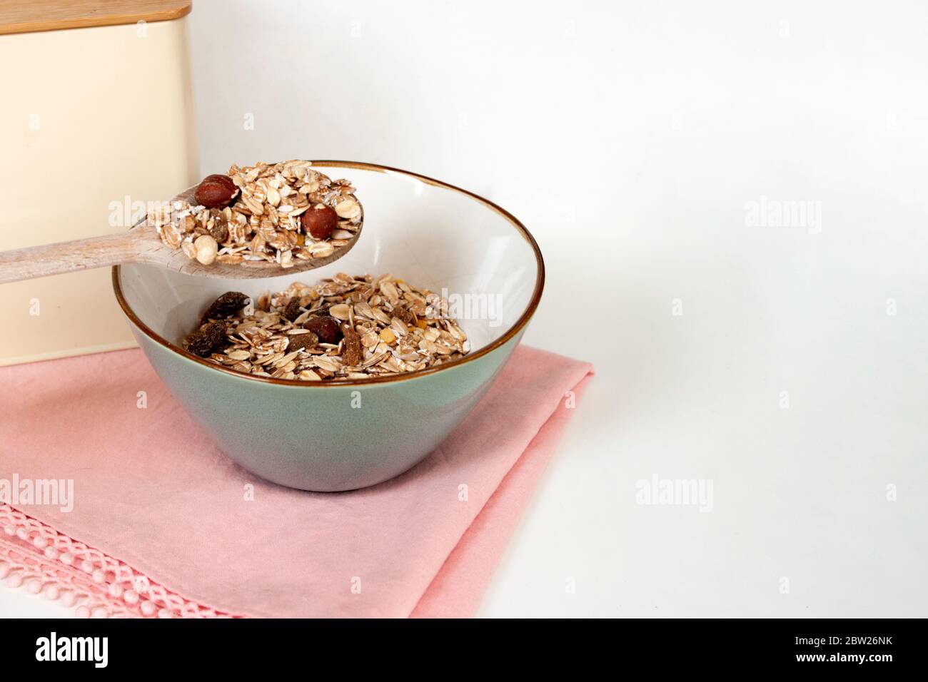 Petit déjeuner à base de muesli, plats d'avoine dans un bol en céramique avec une cuillère à bois. Une alimentation saine. Copier le texte d'espace. Banque D'Images