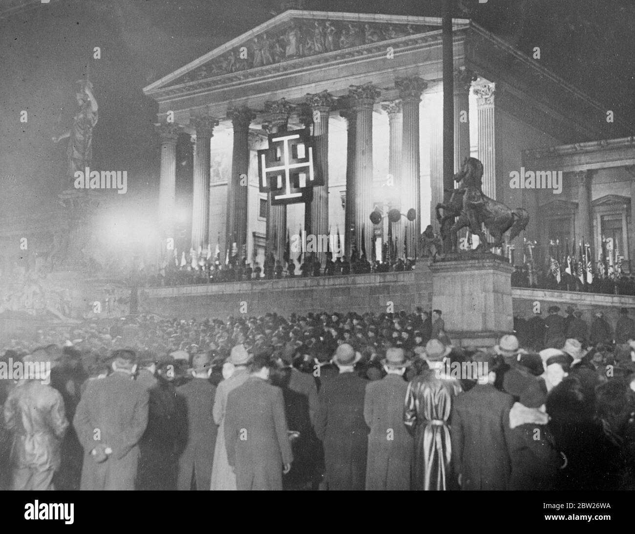 « l'Autriche restera libre ! », le discours provocateur du Dr Schuschnigg, dans lequel il a prononcé son discours devant le Parlement autrichien après son accord avec Hitler, souligne le fait que l'indépendance autrichienne serait maintenue. "L'Autriche restera libre", a-t-il déclaré, "et pour ce combat. Nous allons nous battre jusqu'à la mort. Heil Autriche!'. Après son discours, il a dirigé une foule de 4000 partisans à travers Vienne. Des séances photo, la foule écoutant devant le Parlement éclairé de Vienne alors que le discours de la chancelière était relayé par des haut-parleurs. 25 février 26 1938 Banque D'Images