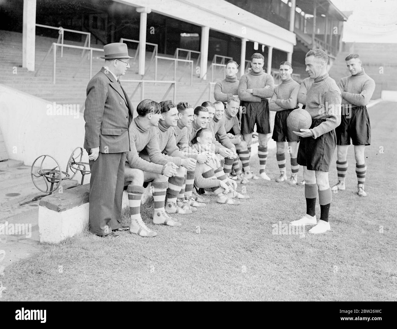 Bob John entraîne les joueurs de West Ham, l'entraînement pour la nouvelle saison de football commence. Les footballeurs West Ham ont rapporté au terrain d'Upton Park et l'entraînement pour la nouvelle saison a déjà commencé. Cette saison, l'équipe est entraînée par Bob John, l'ancien joueur d'Arsenal. Des séances photo, Bob John donnant une leçon sur le contrôle du ballon aux membres de l'équipe de West Ham First à Upton Park, sous la surveillance de Charles Paynter, entraîneur du gérant du Club (à gauche). 26 juillet 1938 Banque D'Images