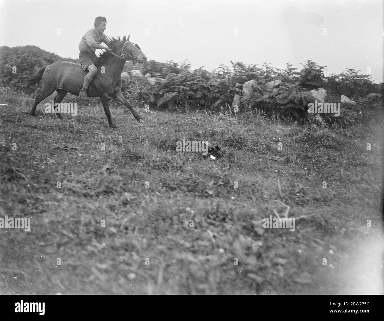 Un garçon qui fait du cheval, du bareback, galopant sur un terrain. 1933 Banque D'Images