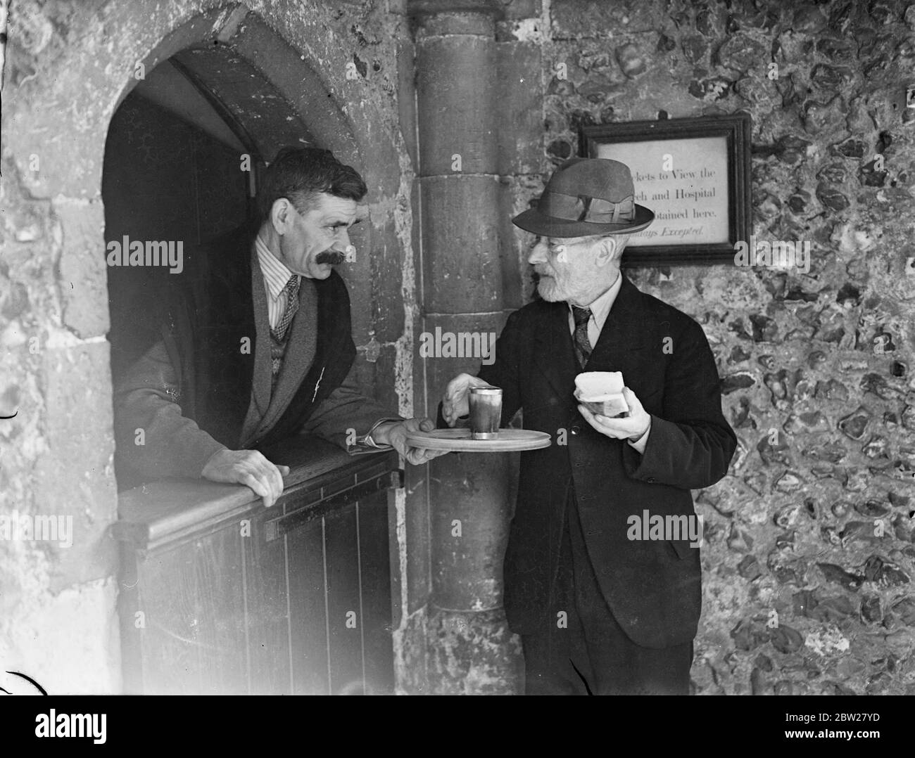 Où la coutume hospitalière d'un siècle survit. ALE et pain gratuits pour les guideurs. Survie des anciens monastères où les wayfarers ont reçu nourriture et abri pour la nuit, il reste encore à l'ancienne ville de Winchester, l'hôpital de St Cross, 800 ans, où une corne d'ALE et une tranche de pain peuvent être eu, gratuitement, par quiconque se soucie de le demander. L'hôpital a été fondé en 1136 pour abriter treize hommes nécessiteux et pour donner de la nourriture et des boissons aux vagabonds pauvres qui pourraient frapper aux portes. Maintenant, les occupants de l'hôpital numéro quinze et sont connus comme Frères de St-Croix. Ils Banque D'Images