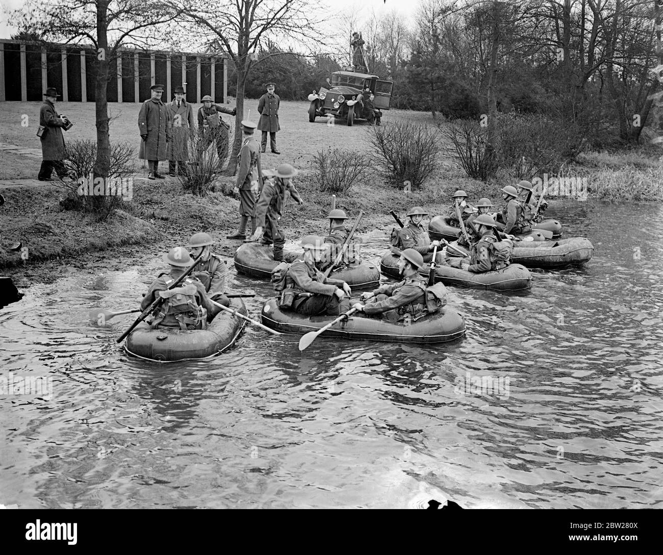 Troupes ford Lake dans des bateaux aérodynamiques à la démonstration d'Aldershot. Les derniers équipements et méthodes d'entraînement des détachements d'infanterie de l'armée britannique ont été démontrés par le premier Batalion le South Staffordshire Regiment dans une série d'exercices à Mytchett, près d'Aldershot, Hampshire. Photos spectacles, , troupes fording Mytchatt Lake en bateaux pneumatiques Aero. Les bateaux, qui peuvent être repliés dans un petit espace, transportent deux hommes avec leur équipement. 21 janvier 1938 Banque D'Images