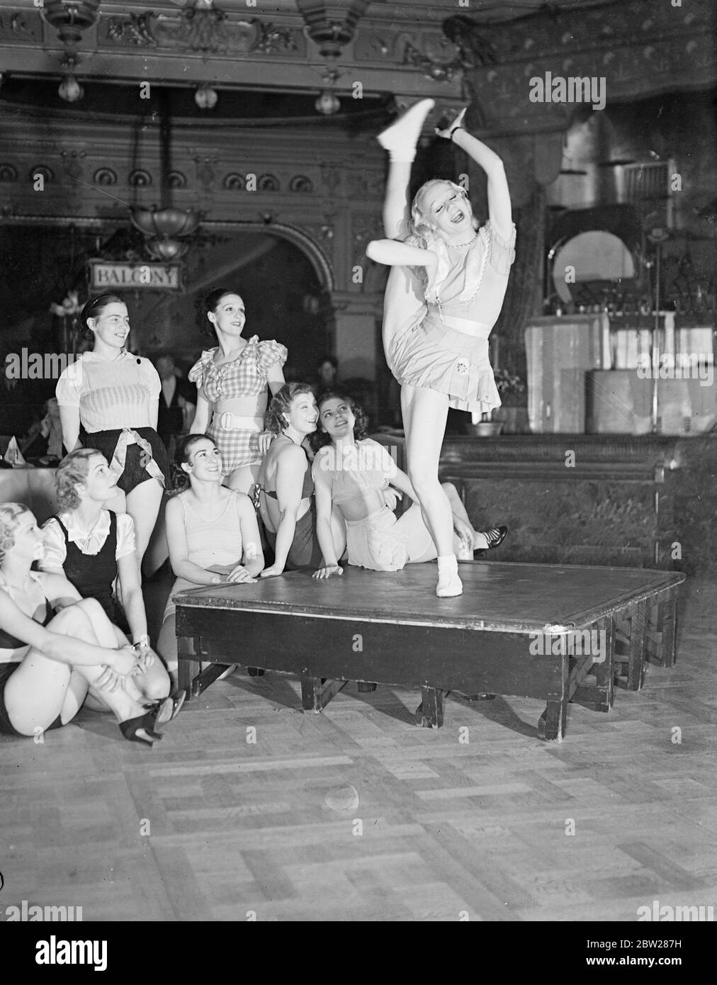 Elle tente de briser son propre record mondial de coup de pied à Londres. Mlle Veronica, titulaire du record mondial de coups de pied, a tenté de battre son propre record lors du championnat du monde au restaurant Frascati's, à Oxford Street. Elle a dû faire plus de 3000 coups de pied consécutifs. Des expositions de photos, Mlle Veronica, qui fait sa tentative de record. Regardée par d'autres concurrents pour le titre mondial. 6 janvier 1938 Banque D'Images