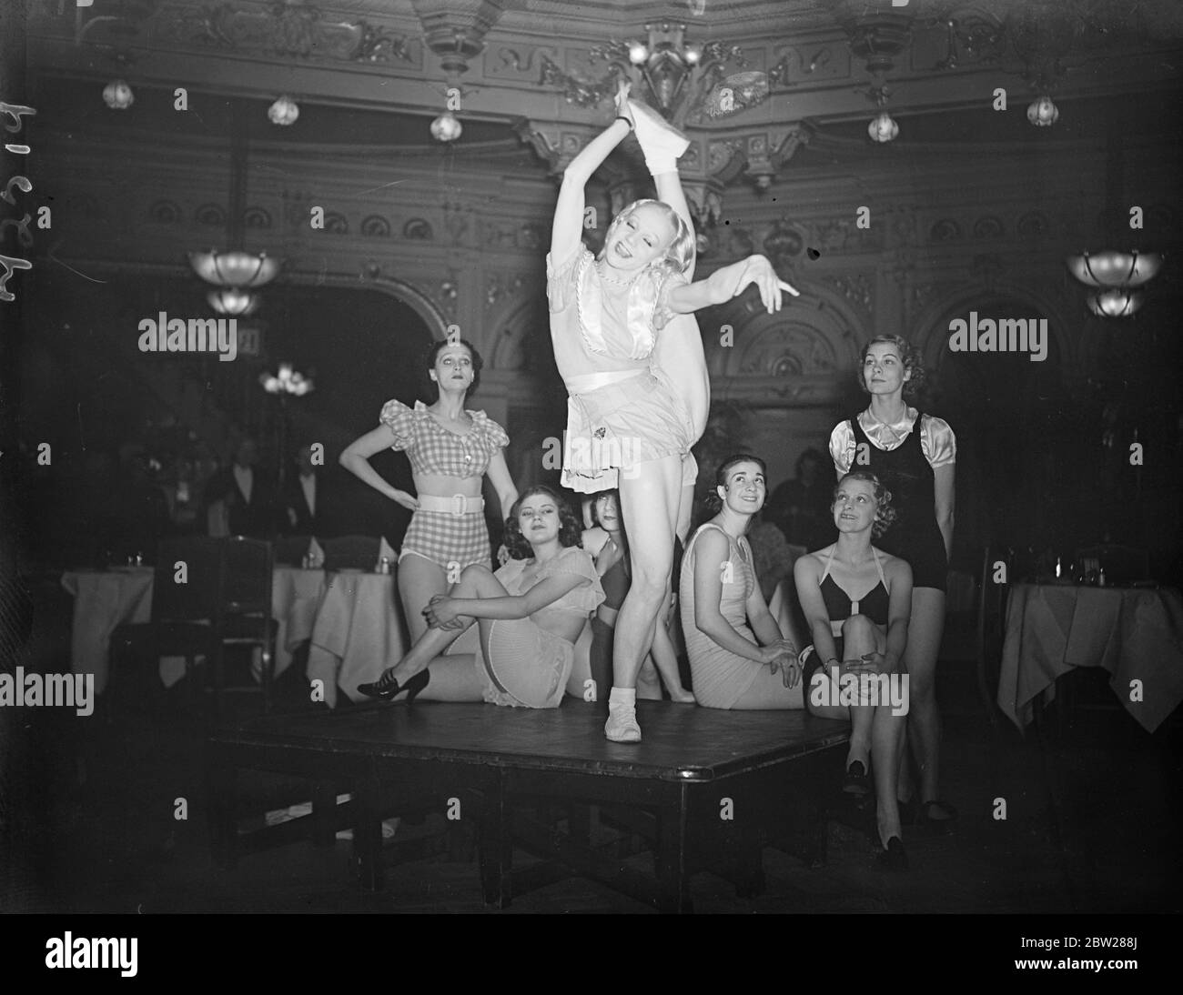 Elle tente de briser son propre record mondial de coup de pied à Londres. Mlle Veronica, titulaire du record mondial de coups de pied, a tenté de battre son propre record lors du championnat du monde au restaurant Frascati's, à Oxford Street. Elle a dû faire plus de 3000 coups de pied consécutifs. Des expositions de photos, Mlle Veronica, qui fait sa tentative de record. Regardée par d'autres concurrents pour le titre mondial. 6 janvier 1938 Banque D'Images