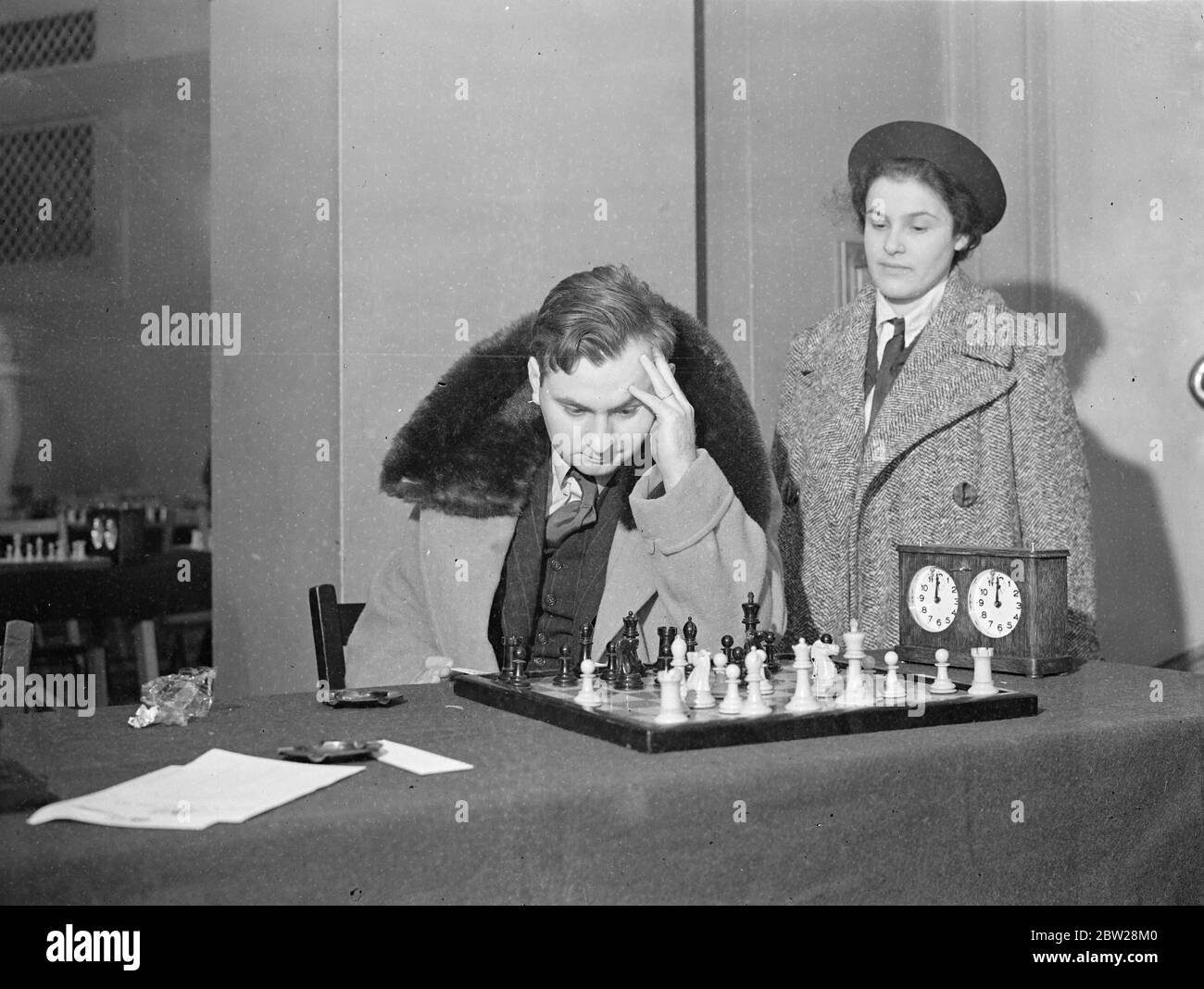 Reuben fine et sa femme, au Hastings International Chess Congress. Maîtres dans un collier de fourrure.. Beaucoup des plus grands maîtres d'échecs du monde prennent part au Congrès international des échecs de Noël de Hastings, qui a ouvert à la vidéo de rock blanc, Hastings , (Sussex). Les résultats du tournoi auront probablement une influence importante sur le championnat du monde. Reuben Fine, le maître américain, portant un collier chaud en fourrure, comme il l'a considéré comme sa prochaine étape, regardé par sa femme. 29 décembre 1937 Banque D'Images