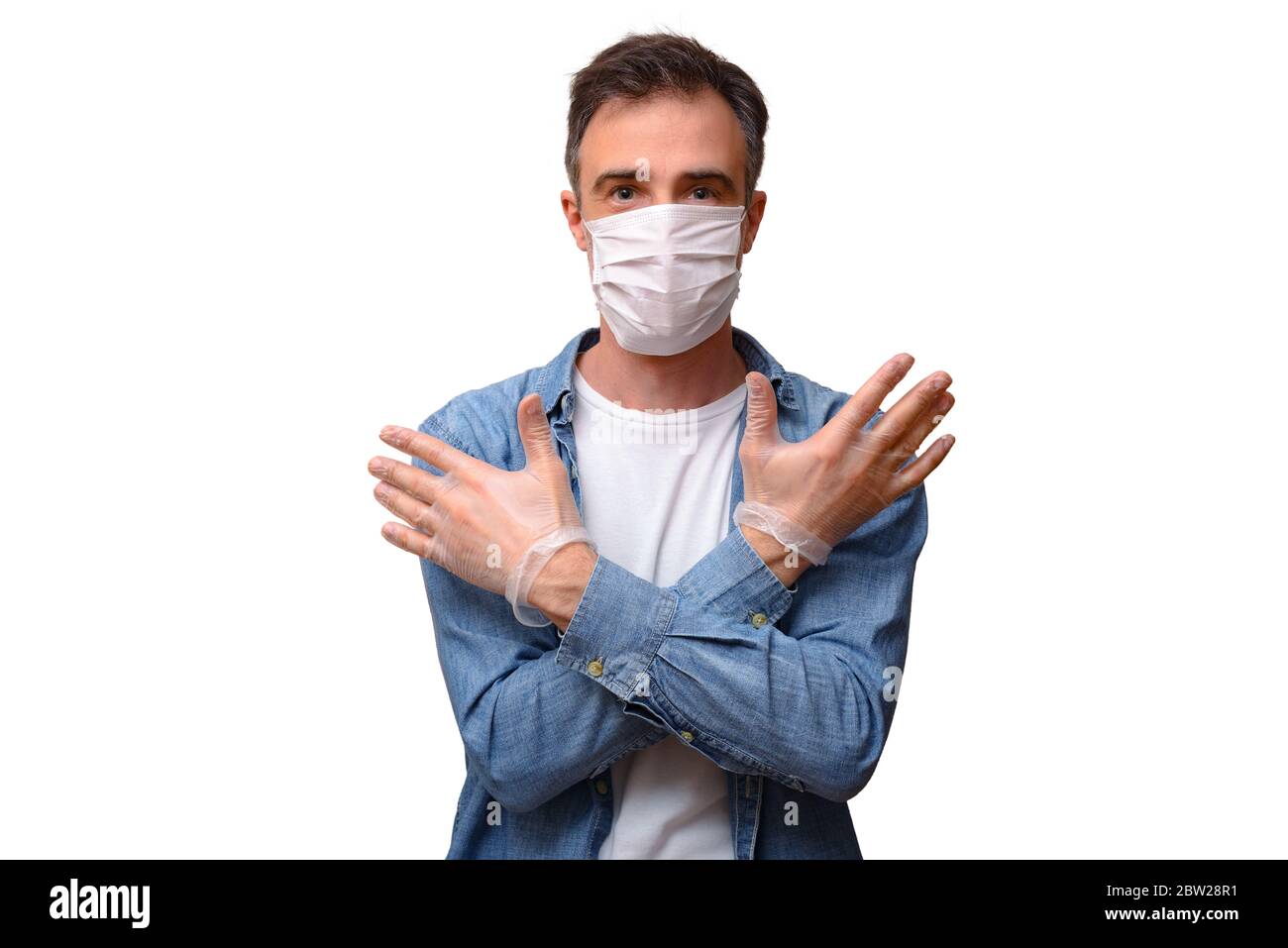Homme adulte décontracté avec masque facial et gants de protection regardant vers l'avant moitié corps avec mains croisées isolé blanc Banque D'Images