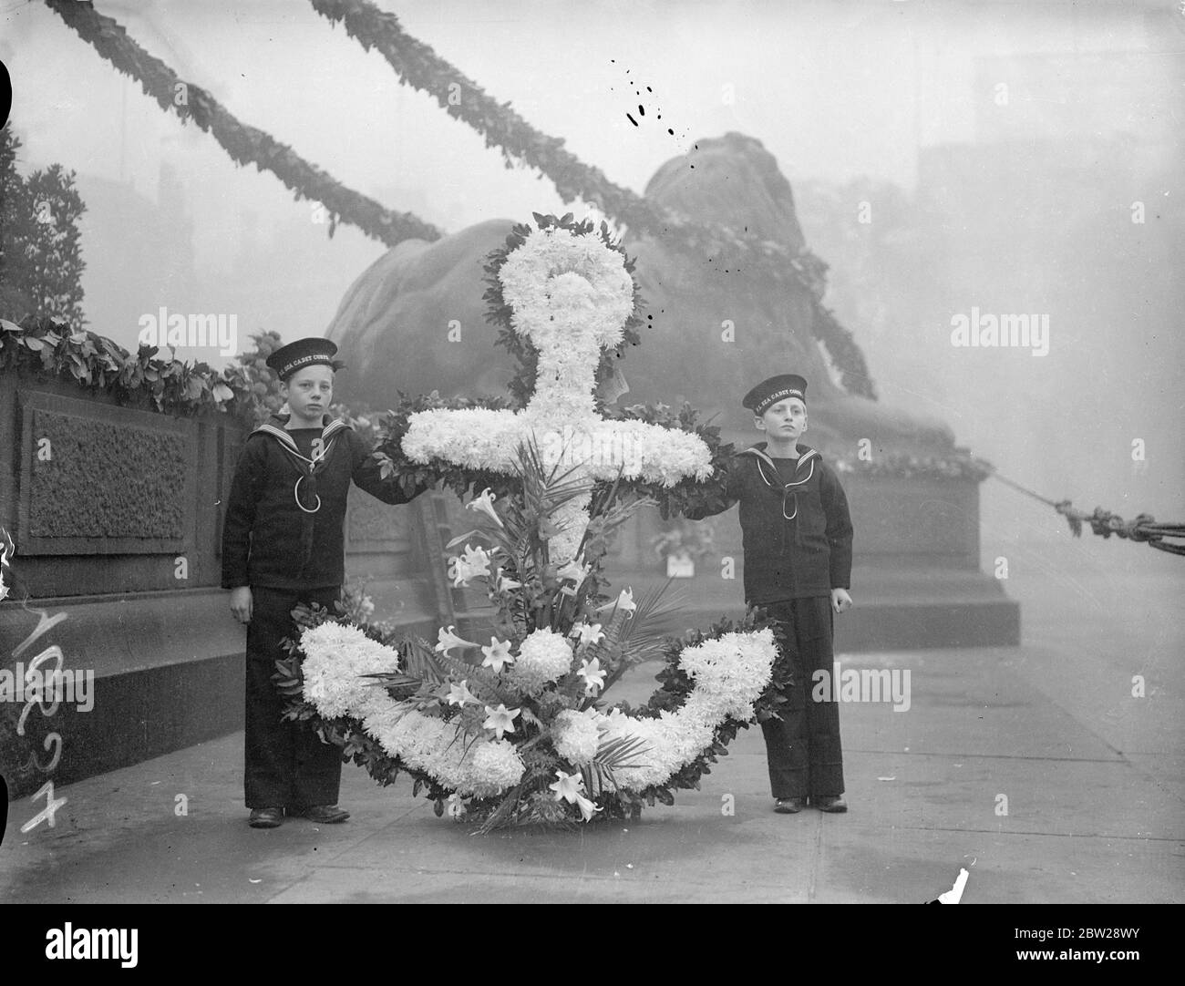 Secrets de la couronne de dépôt sur le monument Nelson le jour de Trafalgar.. Des couronnes ont été posées sur la colonne Nelson de Trafalgar Square le jour de Trafalgar. C'est le 132e anniversaire de la bataille. Expositions de photos, deux jeunes membres du corps des cadets de la Marine, avec une couronne de la caserne navale royale de Portsmouth, à la colonne Nelson. 21 octobre 1937 Banque D'Images
