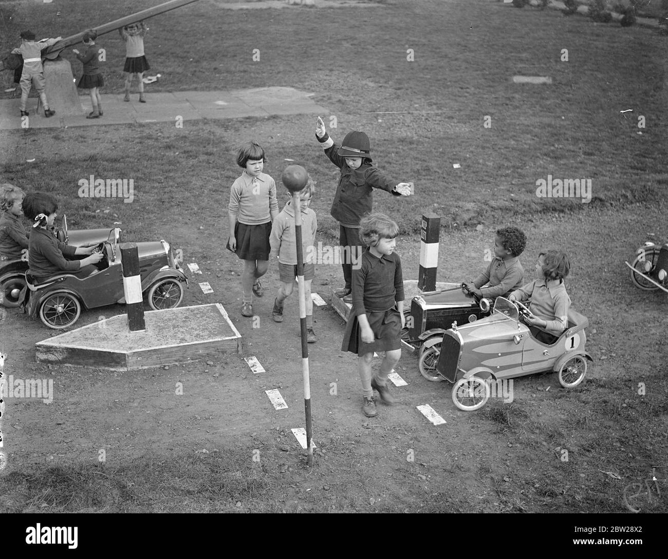 Les enfants ont enseigné le sens de la route sur leur propre autoroute à l'école d'Essex. Pour enseigner la route envoyée aux 500 élèves de l'école résidentielle Hutton (ICC) près de Brentwood, Essex, un système de route miniature complet avec toutes les enseignes d'autoroute approuvées a été mis en place par les élèves dans une partie du terrain. Les enfants acteurs 'policier' tandis que d'autres conduisent des moteurs jouets à et à. Une section de route est toujours en haut. Le projet est l'idée du chef de la Cour, M. RC Higdon, et il a également institué et mis en cour des délinquants. Des spectacles de photos, des enfants passant par une traversée piétonne tandis qu'un policier maintient la circulation des voitures jouets. Banque D'Images