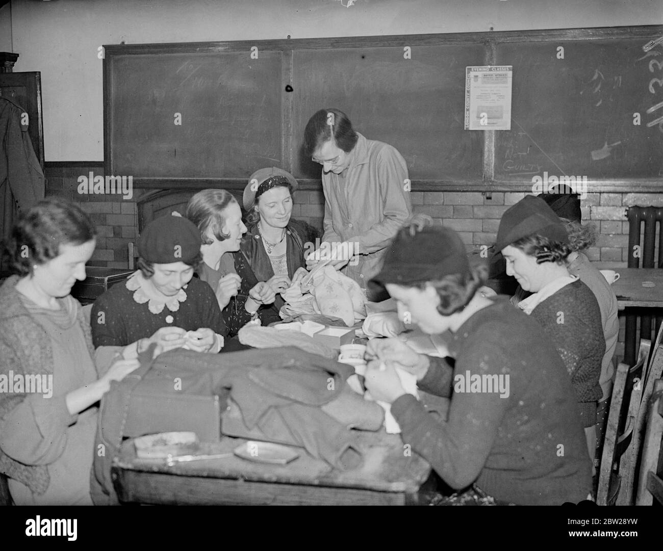 École de Londres où les femmes peuvent apprendre à être de bonnes épouses. Une école spéciale. Enseigner aux femmes à être de bonnes femmes est mené à la rue Sayer, Women's Institute, Wolworth. Les cours, beaucoup d'entre eux sont des cours de soirée incluent tout, de la cuisine au travail du bois. Les élèves de 15 à 90 ans vont à l'école, même s'il ne s'agit que d'un cours 'plus frais'. Il y a beaucoup de grands-mères qui prennent des cours de cuisine. Deux jeunes femmes assistant à des cours de travail du bois ont fait pratiquement tout pour une suite de chambre. Expositions de photos, étudiants au travail dans la classe de travail dans les aiguilles. 22 novembre 1937 Banque D'Images