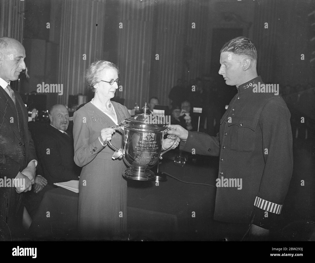 Lady Mayoress remet des prix à la police de la ville de Londres. La Lady Mayoress, Lady Twyford, a remis des prix et des prix pour bravoure à la police de la ville de Londres dans le manoir de Londres. Expositions de photos, la Dame Mayoress, présentant la Mathi Cup pour le tir automatique au pistolet à l'agent de police Waissen. 8 décembre 1937 Banque D'Images