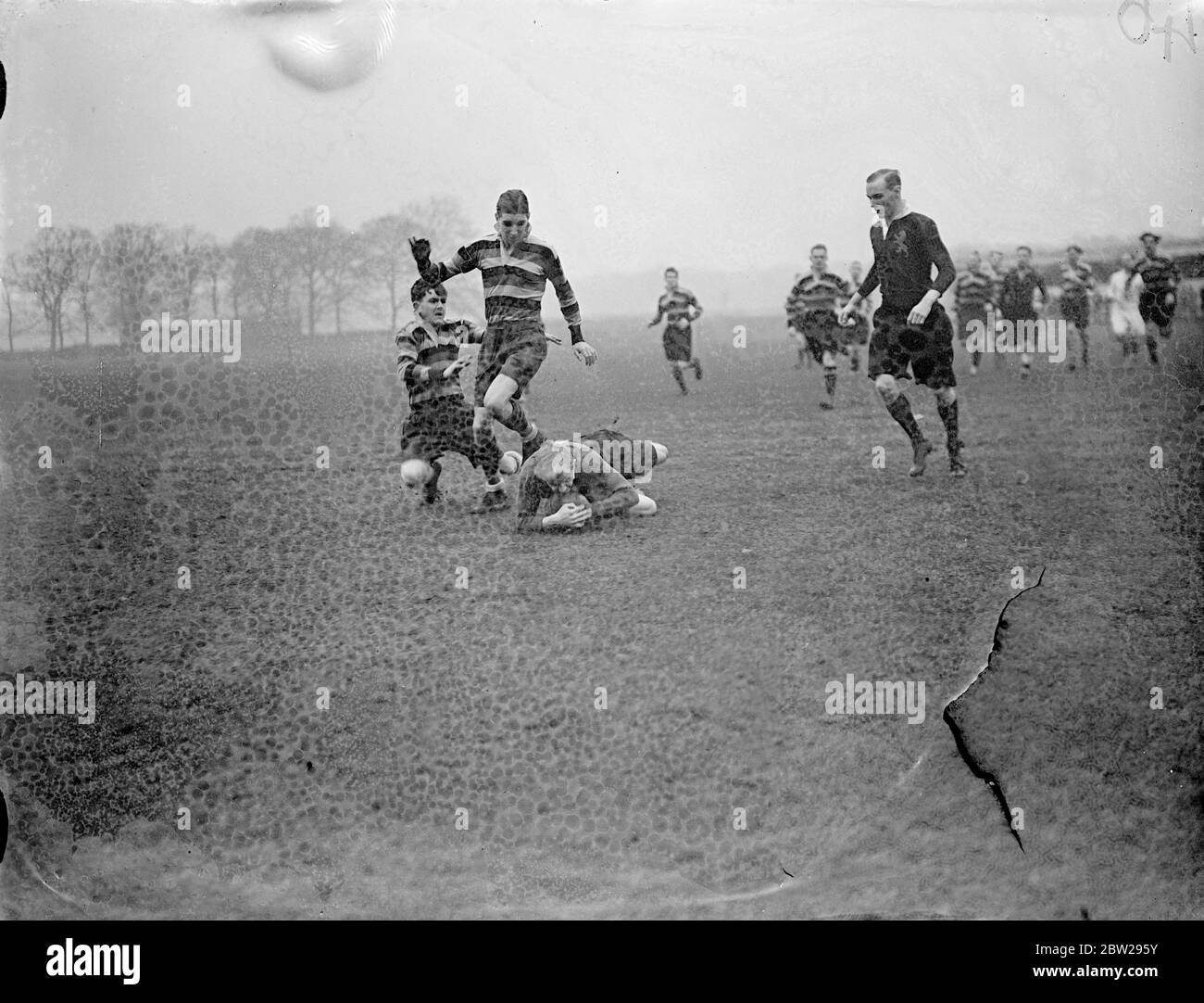 Angleterre contre Ecosse dans les écoles publiques match de rugby. Des garçons d'école publique anglaise ont rencontré l'Écosse lors d'un match de rugby au terrain de sport de Richmond, Richmond, Surrey. Des spectacles de photos, un joueur écossais va s'enfermer dans le ballon avec deux joueurs anglais en présence étroite le 31 décembre 1937 Banque D'Images