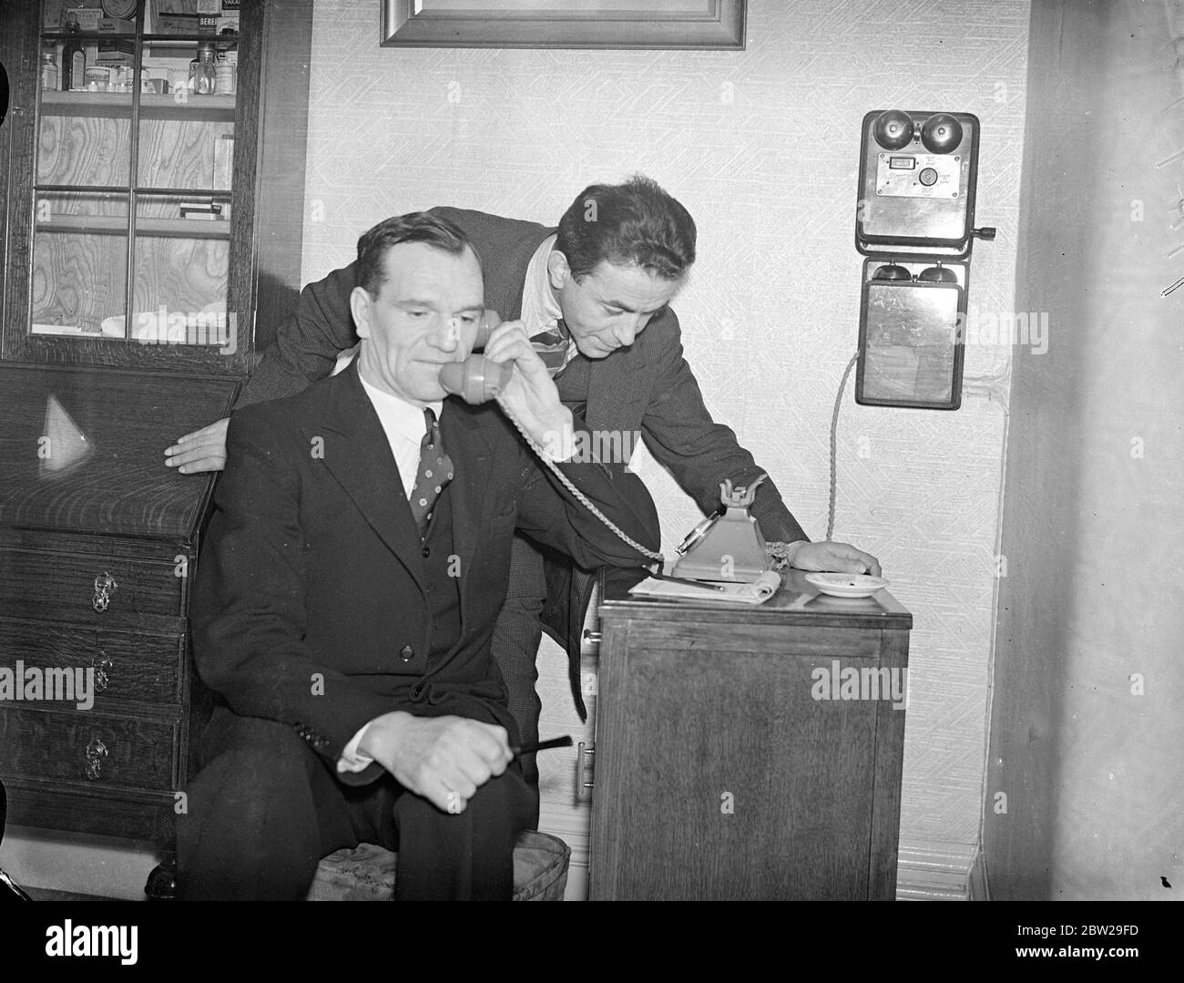 Ilford Man sauvera la vie d'un autre 3000 miles loin. L'appel téléphonique Atlantique apporte espoir. Le seul homme au monde qui peut sauver la vie d'un homme de Windsor, en Ontario, qui souffre d'une maladie rare du sang, a été trouvé à Ilford, à London, après une longue recherche. Il est M. Edgar Harding Stanford, de Kensington Gardens, Ilford, qui a souffert de la même maladie. M. Stanford, par l'intermédiaire de son médecin, M. J Ross, a offert son sang pour transfusion et se rendra à Windsor. Les arrangements sont faits par téléphone transatlantique. Photos, M. Edgar Harding Stanford, parlant par téléphone à Banque D'Images