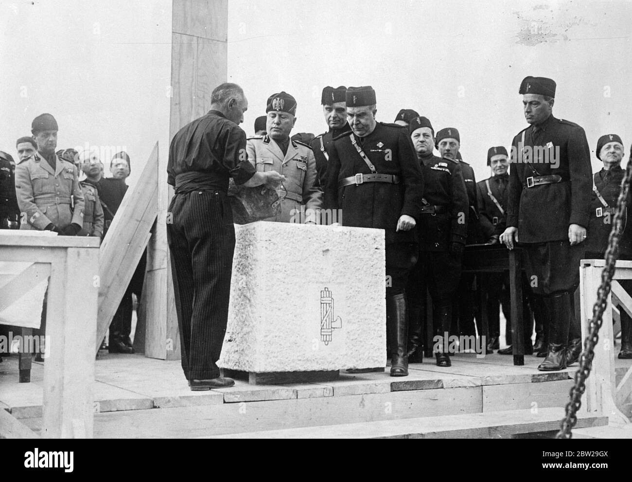 Signor Mussolini pose la pierre de fondation du premier bâtiment de Rome, 1941, exposition. Signor Mussolini a posé la pierre de fondation du premier bâtiment de la grande exposition universelle à ouvrir, près de Rome en 1941. Expositions de photos, Signor Mussolini posant la pierre de fondation . Le Sen Gini, commissaire général de l'exposition, se trouve à côté de lui à droite. 22 octobre 1937 Banque D'Images
