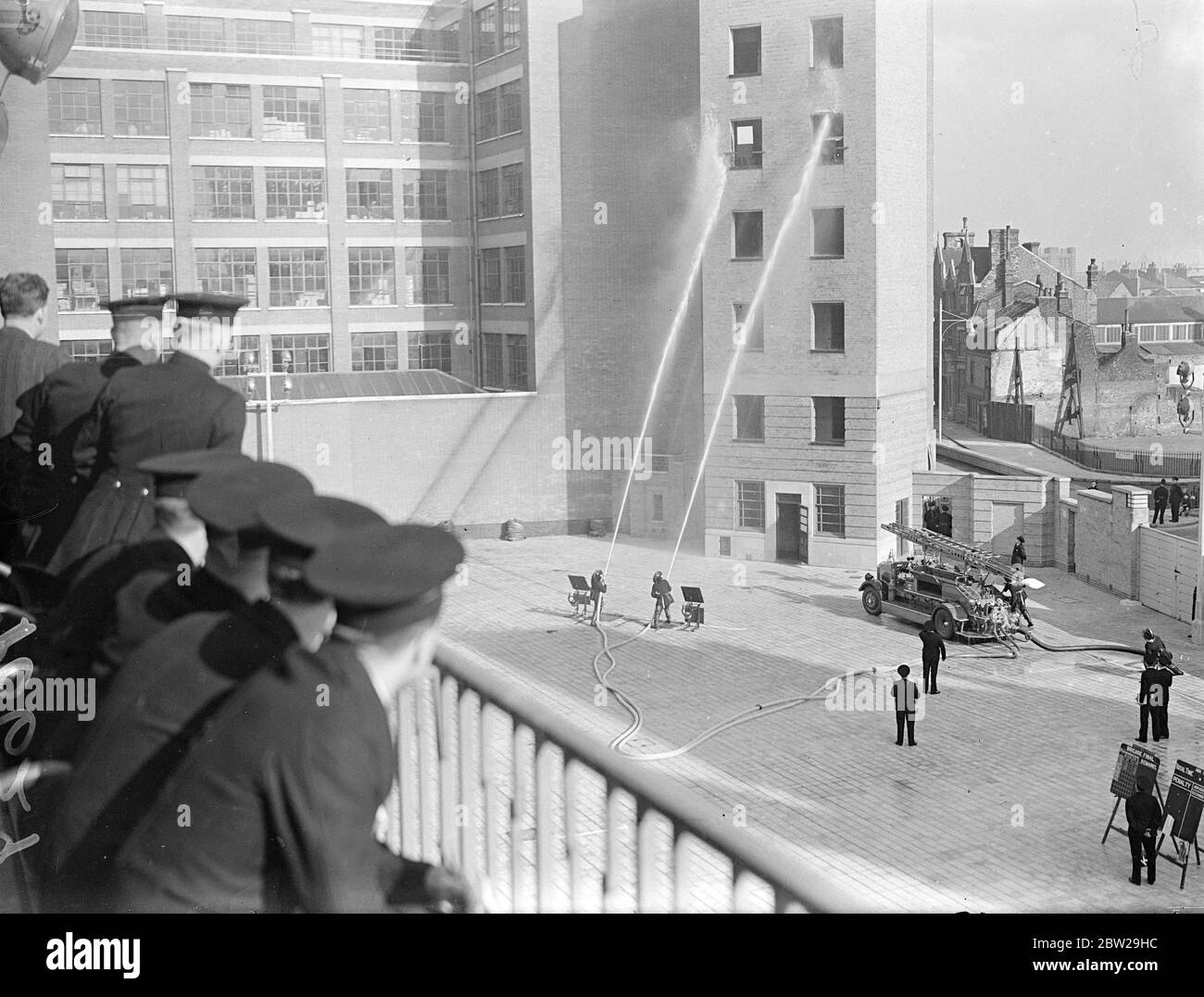 Finale de la compétition de pompe de la Brigade des pompiers de Londres. La finale de la compétition de pompe de la Brigade des pompiers de Londres a eu lieu pour la première fois au nouveau quartier général sur le remblai Albert. Six équipes ont participé. L'équipe gagnante était le no 40 nouvelles séries de photos de croix B, l'équipe no 63 de Cannon Street B pompant de l'eau sur des cibles dans la tour d'entraînement. 26 octobre 1937. Banque D'Images