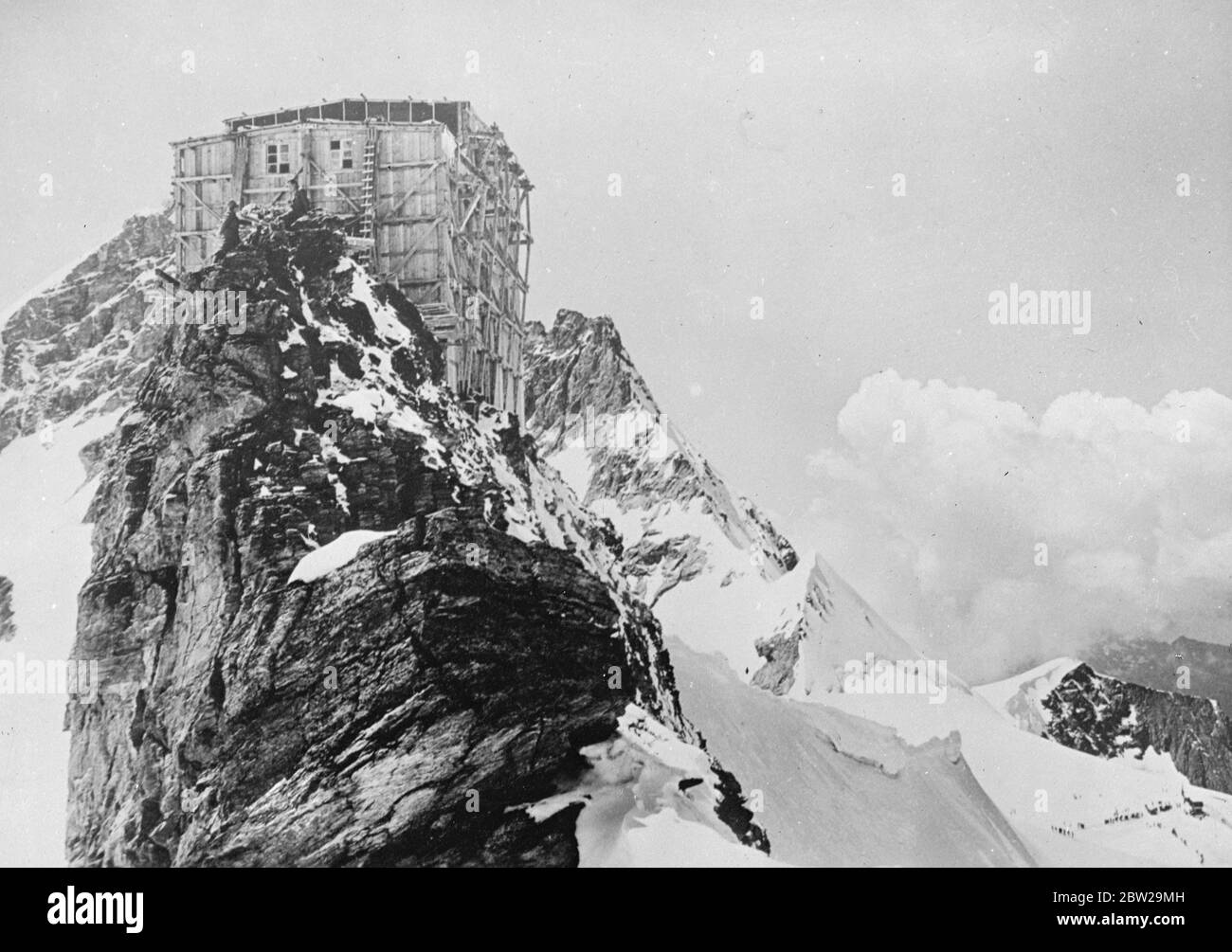 La station de recherche la plus élevée d'Europe est proche de la fin. Perchée sur le pic accidenté du Sphinx, qui s'élève à près de 12,000 mètres de haut dans les Alpes suisses, la station de recherche la plus loftite d'Europe est sur le point d'être achevée. À la station, les scientifiques briseront les rigueurs du vent et du blizzard pour étudier les conditions météorologiques et atmosphériques à haute altitude. 18 octobre 1937 Banque D'Images