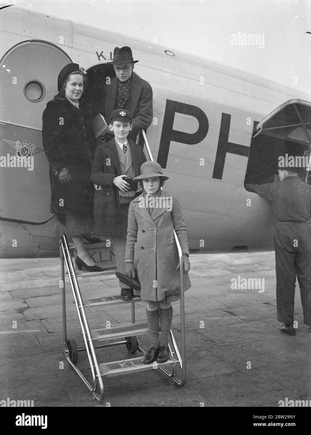 Fête de famille d'école, laisse par a pour passer Noël avec le père à Karachi. Une famille de garçons et de filles d'école, à gauche, l'aérodrome de Croydon par le KLM liner pour Karachi, où ils doivent passer leurs vacances de Noël. Le chef des partis, M. H Monroe, de Rugby, âgé de 20 ans, qui, avec ses sœurs, se joint à leur père, juge de paix à Karachi. Photoshows, M. H H Monroe avec ses sœurs, Miss A Monroe, 17 ans (Somerfield College, Oxford), Miss N Monroe (10) et un ami, J Coldstream, 11 ans, qui voyage avec eux, signe le départ de Croydon. 6 décembre 1937 Banque D'Images Fête de famille d'école, laisse par a pour passer Noël avec le père à Karachi. Une famille de garçons et de filles d'école, à gauche, l'aérodrome de Croydon par le KLM liner pour Karachi, où ils doivent passer leurs vacances de Noël. Le chef des partis, M. H Monroe, de Rugby, âgé de 20 ans, qui, avec ses sœurs, se joint à leur père, juge de paix à Karachi. Photoshows, M. H H Monroe avec ses sœurs, Miss A Monroe, 17 ans (Somerfield College, Oxford), Miss N Monroe (10) et un ami, J Coldstream, 11 ans, qui voyage avec eux, signe le départ de Croydon. 6 décembre 1937 Banque D'Images