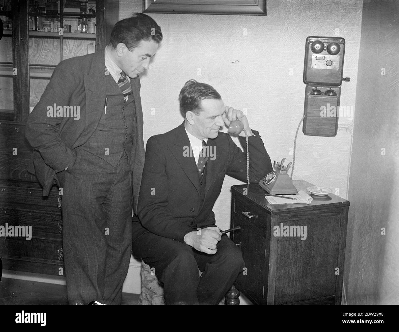 Ilford Man sauvera la vie d'un autre 3000 miles loin. L'appel téléphonique Atlantique apporte espoir. Le seul homme au monde qui peut sauver la vie d'un homme de Windsor, en Ontario, qui souffre d'une maladie rare du sang, a été trouvé à Ilford, à London, après une longue recherche. Il est M. Edgar Harding Stanford, de Kensington Gardens, Ilford, qui a souffert de la même maladie. M. Stanford, par l'intermédiaire de son médecin, M. J Ross, a offert son sang pour transfusion et se rendra à Windsor. Les arrangements sont faits par téléphone transatlantique. Photos, M. Edgar Harding Stanford, parlant par téléphone à Banque D'Images