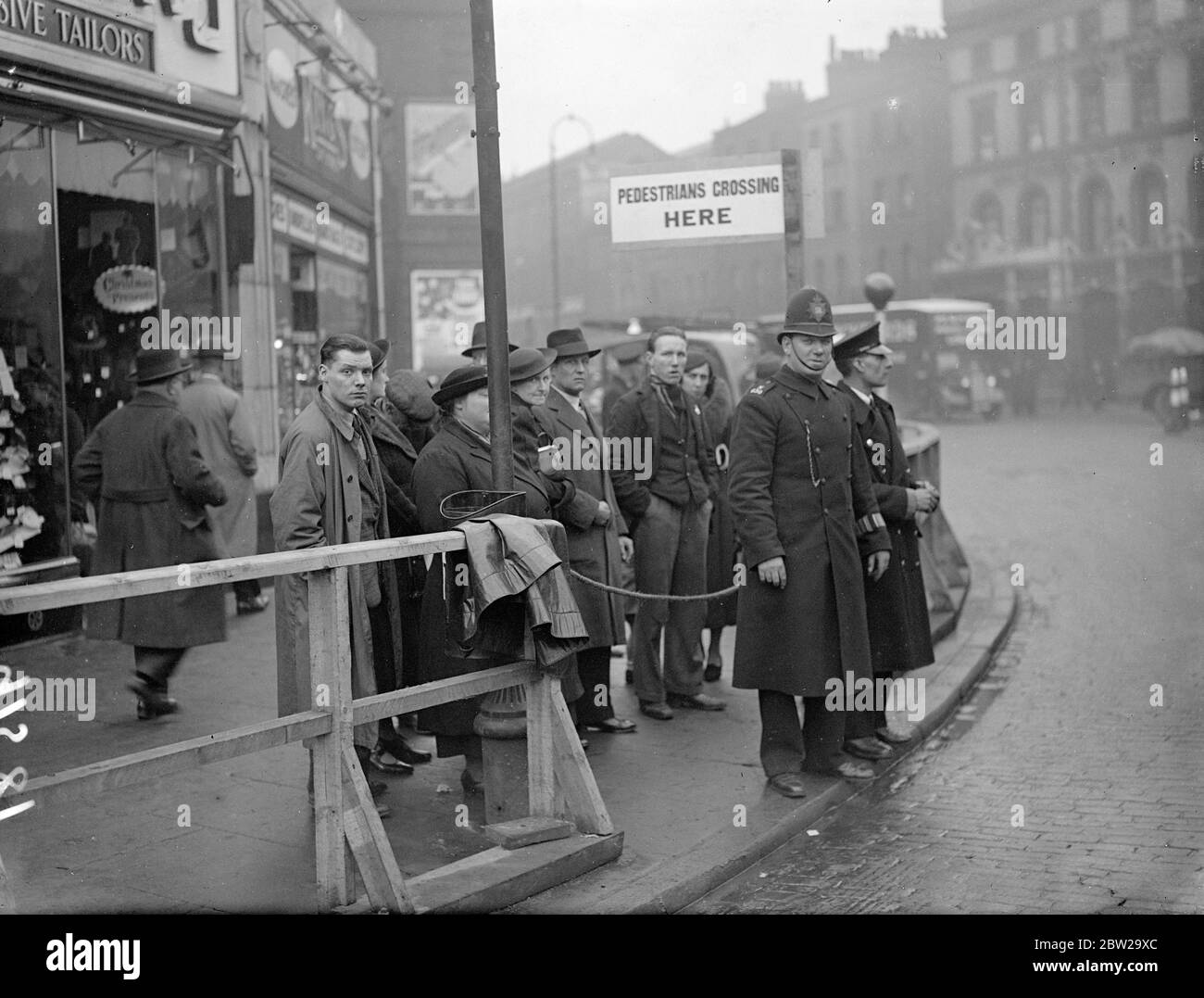 La police a contrôlé les rails pour piétons à Kings Cross- reconstruction de la station de métro. Les travaux de reconstruction de la station de métro de King's Cross ont nécessité l'enlèvement d'une passerelle de la rue au-dessus et des rails pour piétons contrôlés par la police ont été érigés. 1er septembre 1937 Banque D'Images