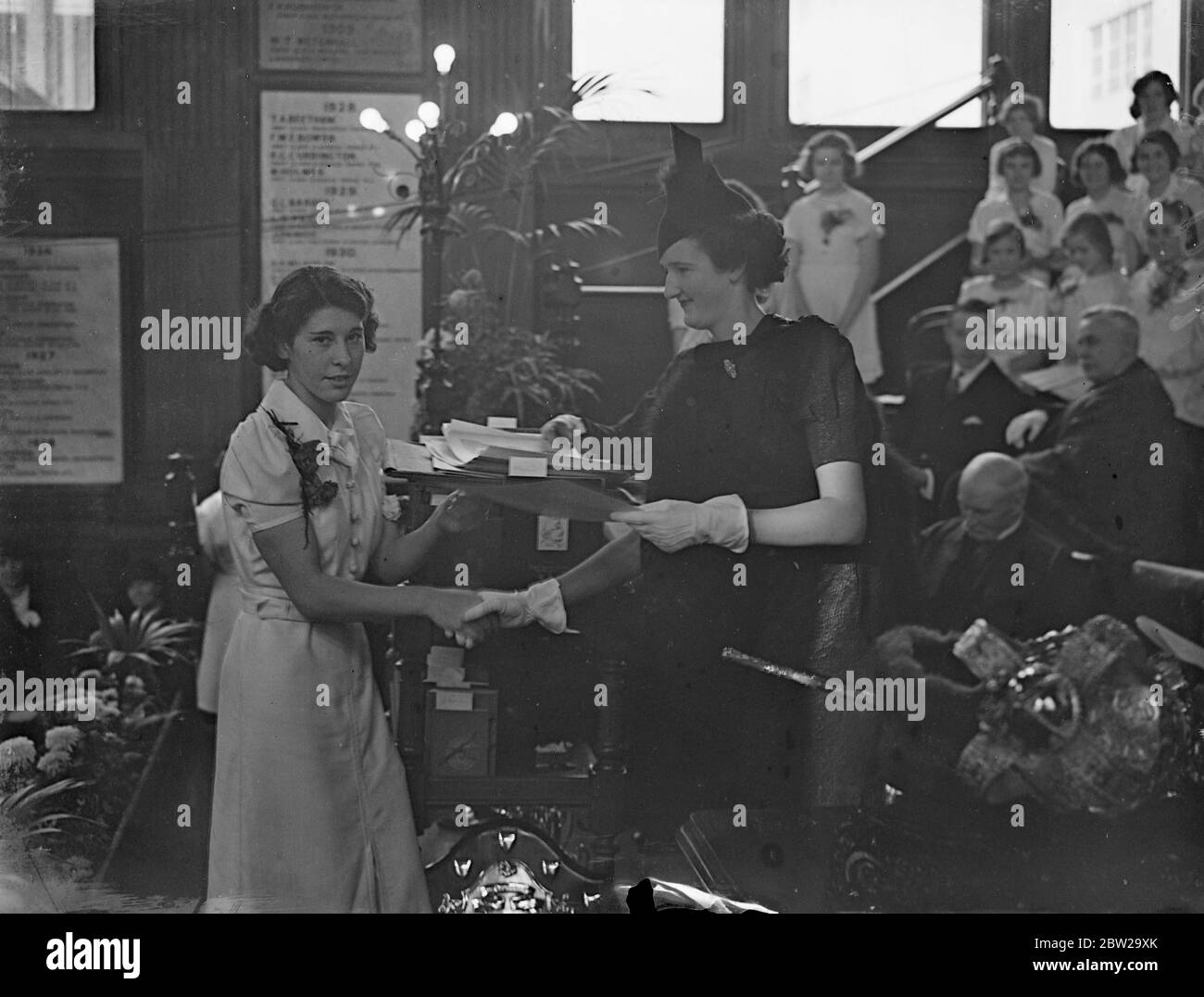 Fille expulse pour Lady Mayoress à la distribution de prix de la ville. Madame Marjorie Broadbridge, fille du Lord Mayor et de la Lady Mayoress de Londres, a été dépuisée pour sa mère, qui était indisposée, lors de la distribution de prix aux chercheurs de la City of London School for Girls. Photos, Mlle Marjorie Broadbridge, fille du maire Lord, présente le certificat à Mlle y Bird, gagnante d'une bourse d'études de la Société. 20 octobre 1937 Banque D'Images