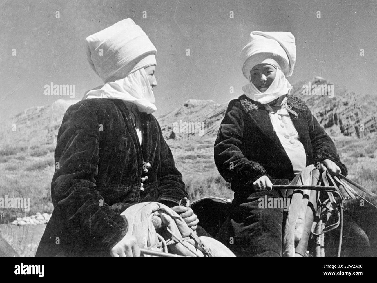 Pointez les électeurs dans la première élection soviétique. Des rives de la mer Noire à l'océan Arctique, plus de 150 millions de personnes, citoyens de l'URSS, votant aujourd'hui dans la plus grande collection du monde, la première jamais tenue en Russie soviétique, et instantanément, la première en vertu de la nouvelle Constitution. Dans cette gigantesque élection. Tous les moyens modernes pour atteindre les électeurs, les avions, les cinémas, la radio et les journaux sont utilisés sans cesse depuis des mois. Photos, à la ferme collective des femmes de Kirghiz, dans leurs costumes nationaux pittoresques . Deux des nombreux types variés flottant dans les Soviétiques première élection. 12 Déc Banque D'Images