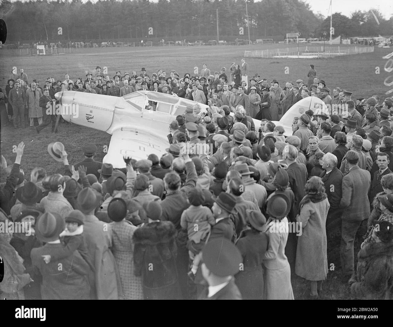 Jean Batten fait 14 1/2 heures de route pour l'Australie et l'Angleterre. Après avoir lutté contre l'épuisement et les galettes sur son dernier tour éprouvant, Jean Batten, la jeune fille aérienne néo-zélandaise, a été accueillie par des foules enthousiastes lorsqu'elle a atterri à Croydon après avoir battu le record de Jim Broadbent de l'Australie en Angleterre de 14 1/2 heures. Elle avait atterri à Lympne, effectuant son premier vol solo en cinq jours et 18 heures, et est arrivée à Croydon. Des expositions de photos, l'avion de Jean Batten étant entouré par la foule lorsqu'elle a atterri à Lympne. 24 octobre 1937 Banque D'Images