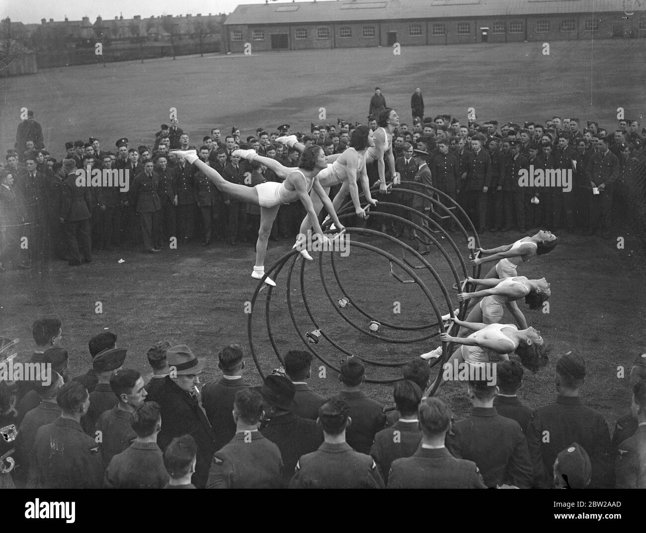 Les filles allemandes montrent aux apprentis de la RAF une nouvelle façon de garder la forme. Une équipe de filles allemandes, les 'Rhoenrads', qui ont été présentés à Londres, a envahi la station de la RAF à Cranwell, à l'invitation du commandant de l'escadre JR Cassidy de faire une démonstration des nouveaux moyens d'améliorer la forme physique aux apprentis du centre. Les filles exécutent des roues ongyro, qui sont utilisées pour enseigner l'équilibre dans toutes sortes de positions. Photos, les filles allemandes qui font la démonstration des roues gyro avant que la RAF ne s'apprentis à Cranwell. 26 novembre 1937 Banque D'Images