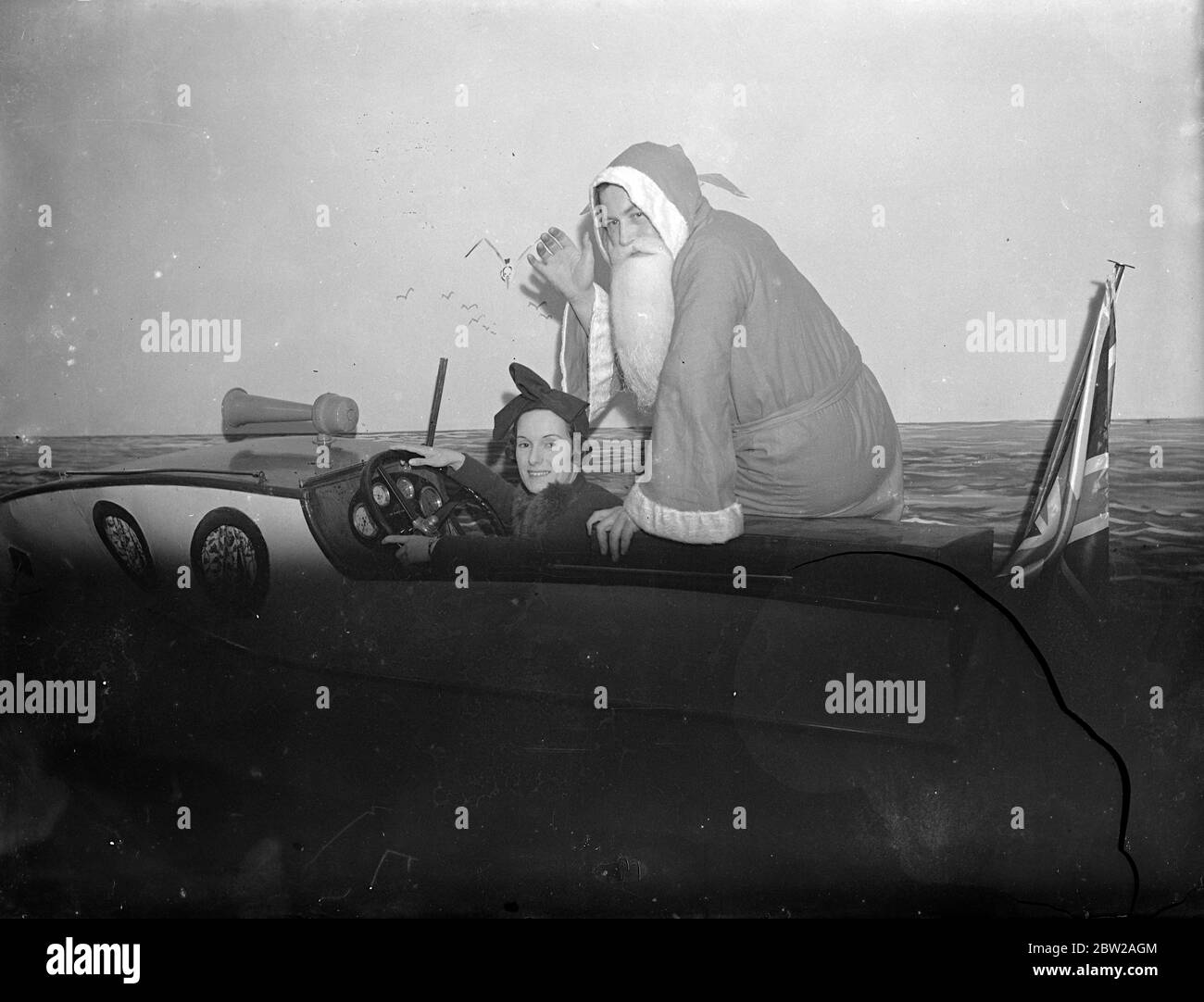 Jean Batten prend Noël père pour une promenade. Mlle Jean Batten, la Air-femme néo-zélandaise qui a récemment battu le record de l'Australie en Angleterre, a ouvert le bazar de Noël à Wallis à Melbourne en bateau à moteur. 9 novembre 1937 Banque D'Images