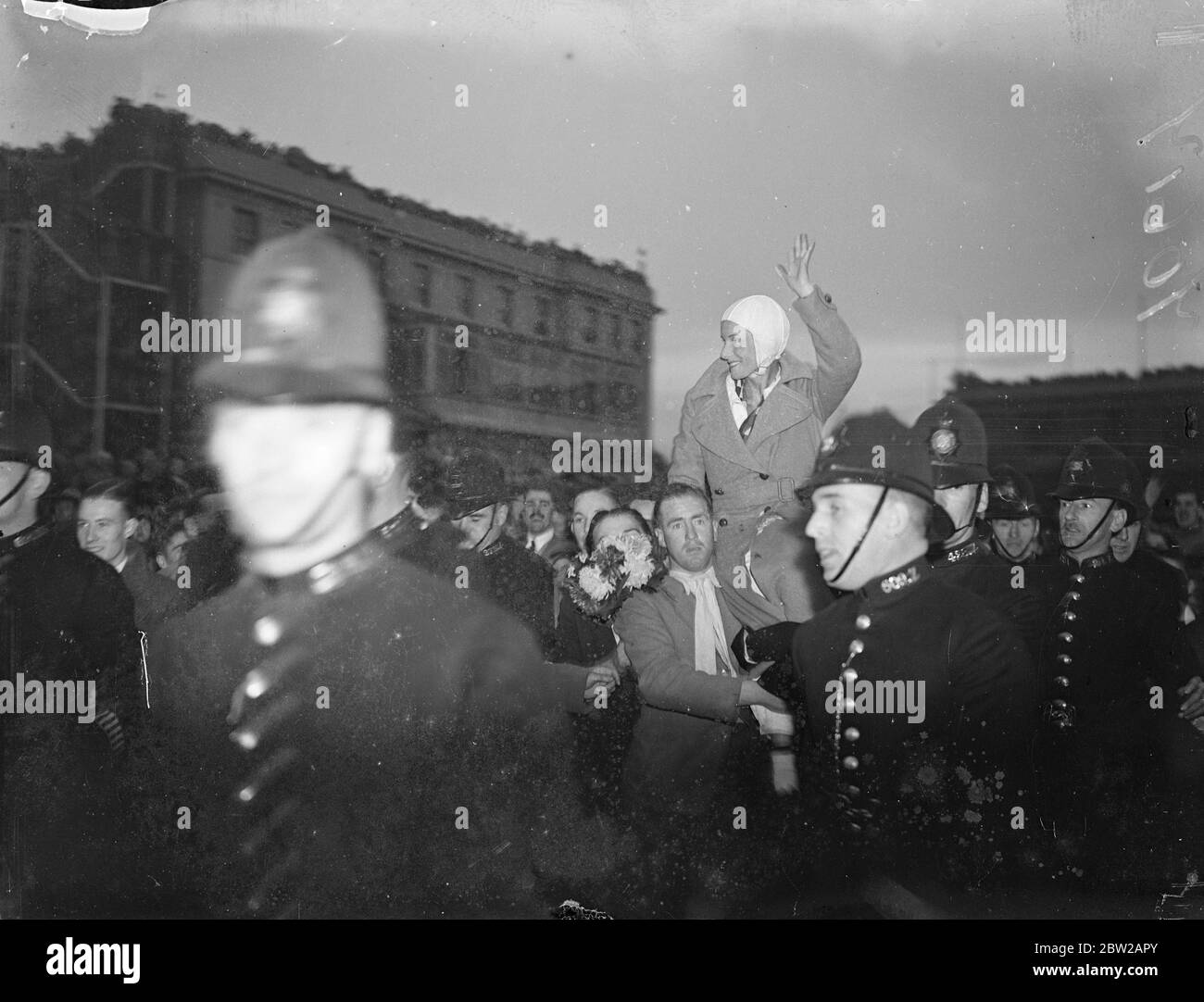 Jean Batten fait 14 1/2 heures de route pour l'Australie et l'Angleterre. Après avoir lutté contre l'épuisement et les galettes sur son dernier tour éprouvant, Jean Batten, la jeune fille aérienne néo-zélandaise, a été accueillie par des foules enthousiastes lorsqu'elle a atterri à Croydon après avoir battu le record de Jim Broadbent de l'Australie en Angleterre de 14 1/2 heures. Elle avait atterri à Lympne, effectuant son premier vol solo en cinq jours et 18 heures, et est arrivée à Croydon. Des spectacles de photos, Jean Batten signe la foule à Croydon alors qu'elle était transportée de son avion. 24 octobre 1937 Banque D'Images