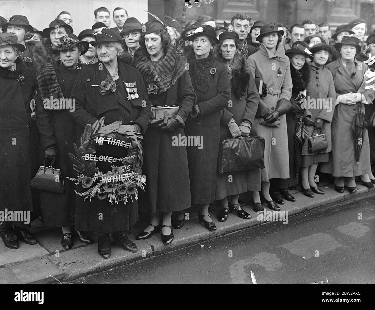 Mère, qui donna trois fils avec sa couronne au Cenotaph. Les mères qui ont perdu des fils pendant la Grande Guerre ont été parmi les premières arrivées au Cenotaph pour le service de jour d'armistice. Photo montre, Madame A Kerr, qui a perdu trois fils dans la guerre, et a maintenant un fils servant à Shanghai, avec une couronne au Cenotaph. 11 novembre 1937 Banque D'Images